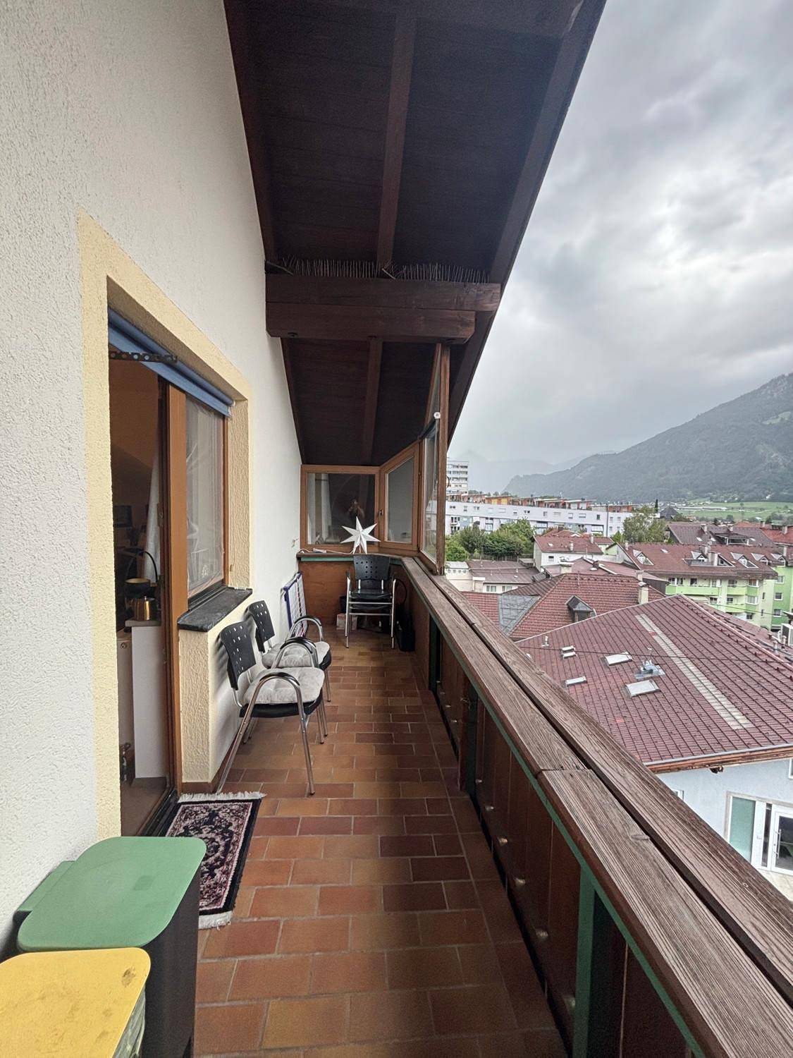 Langer Balkon mit Fliesenboden und Bergblick, ausgestattet mit Sitzgelegenheiten.