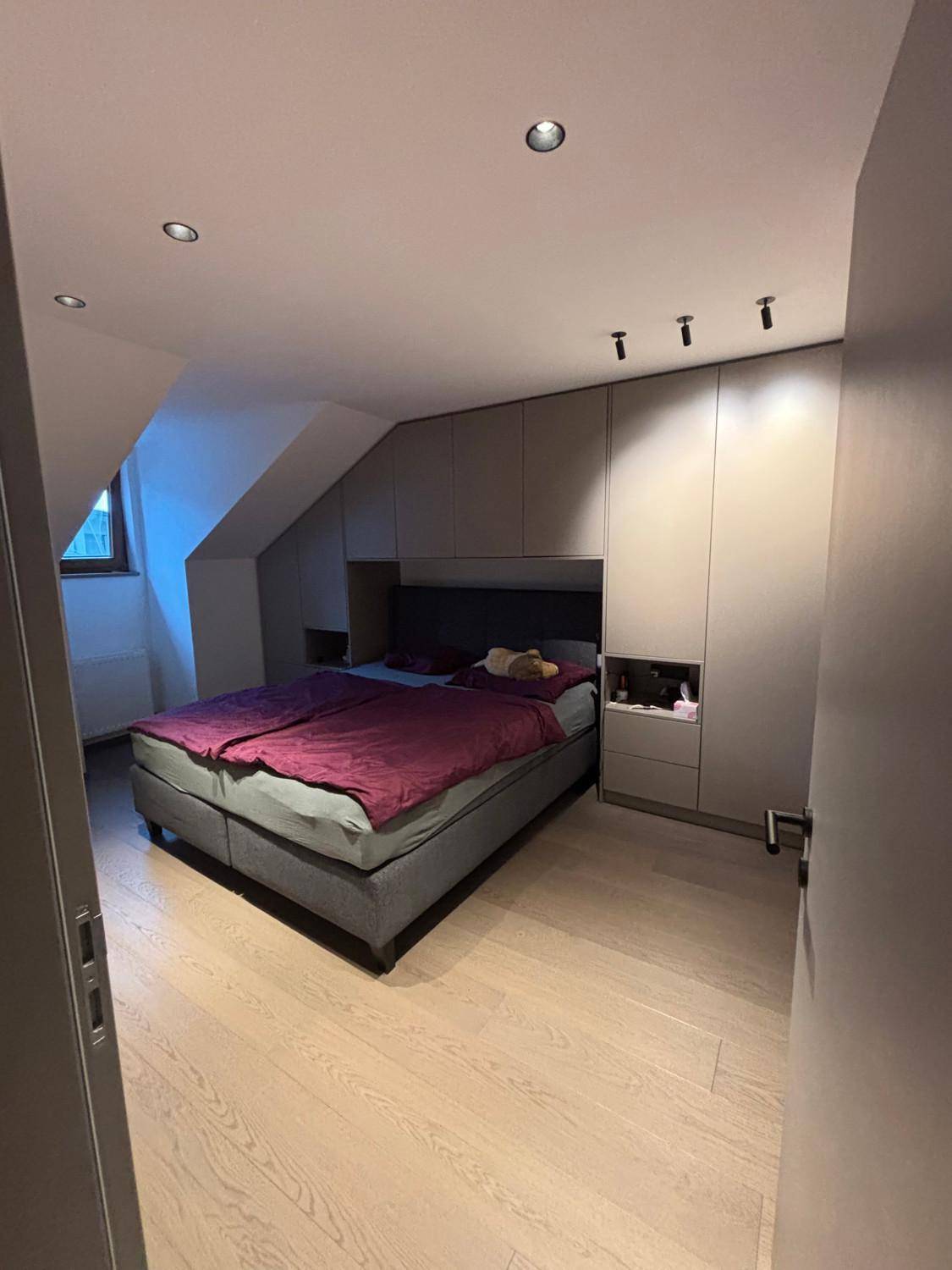 Geräumiges Schlafzimmer mit Doppelbett und Einbauschränken unter der Dachschräge.