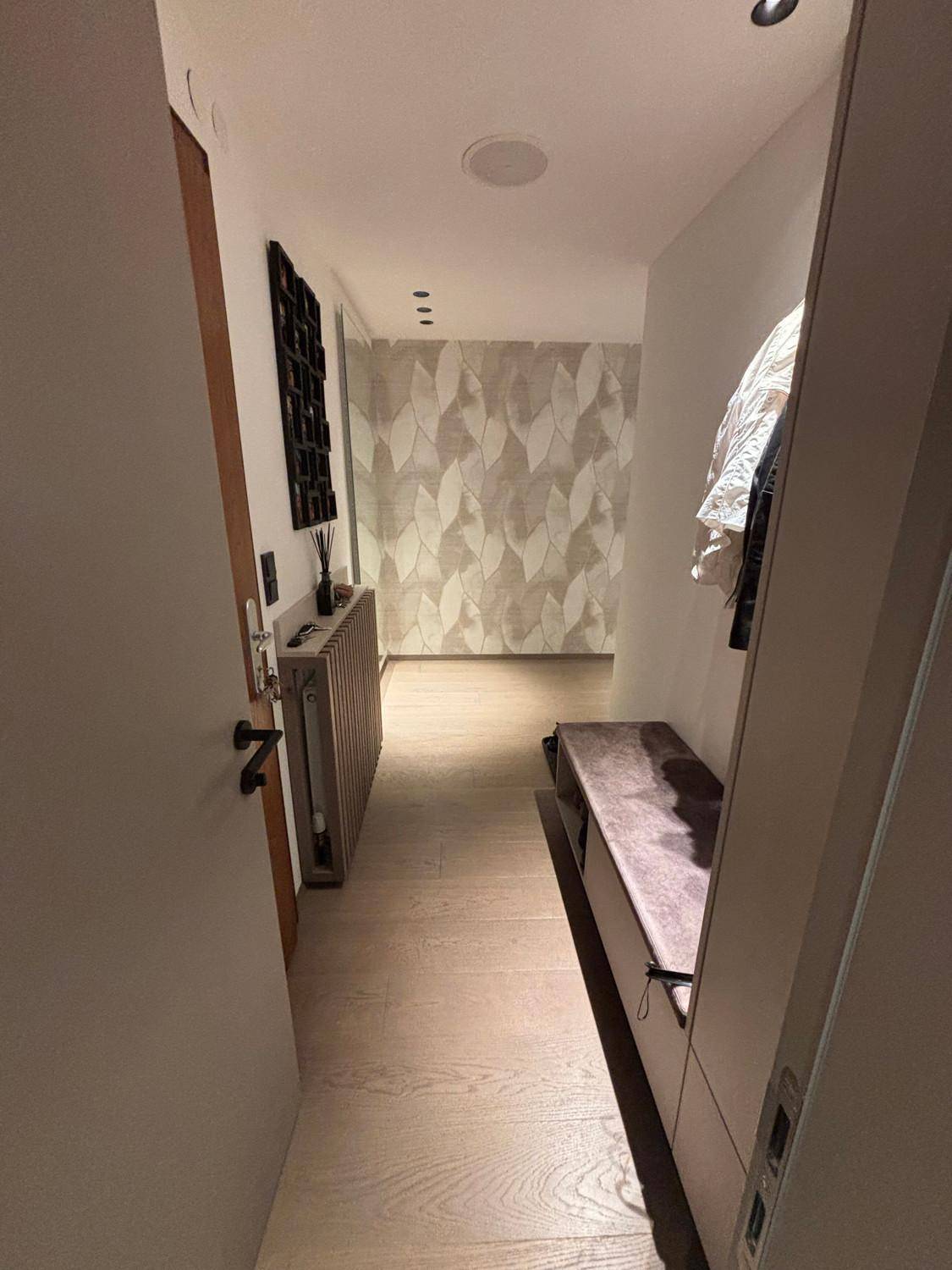 Langer Flur mit Holzboden und stilvoller Wandgestaltung, führt zu weiteren Räumen.