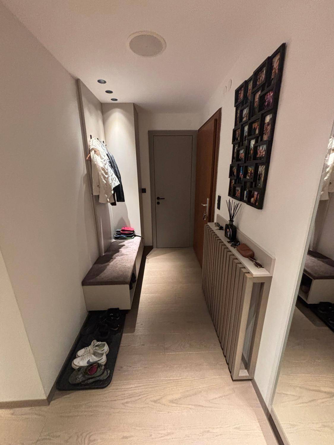 Eingangsbereich mit Garderobe, Sitzbank und Spiegel, ausgestattet mit Holzboden.