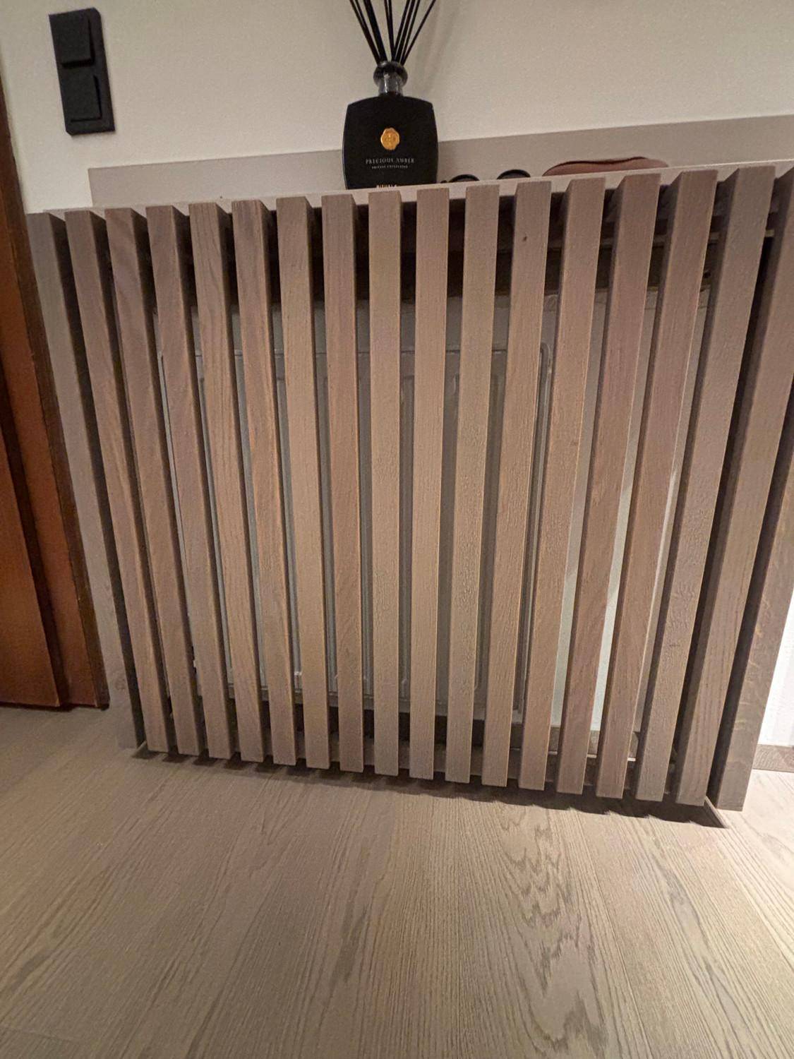 Detailansicht einer modernen Heizkörperverkleidung aus Holzlamellen.