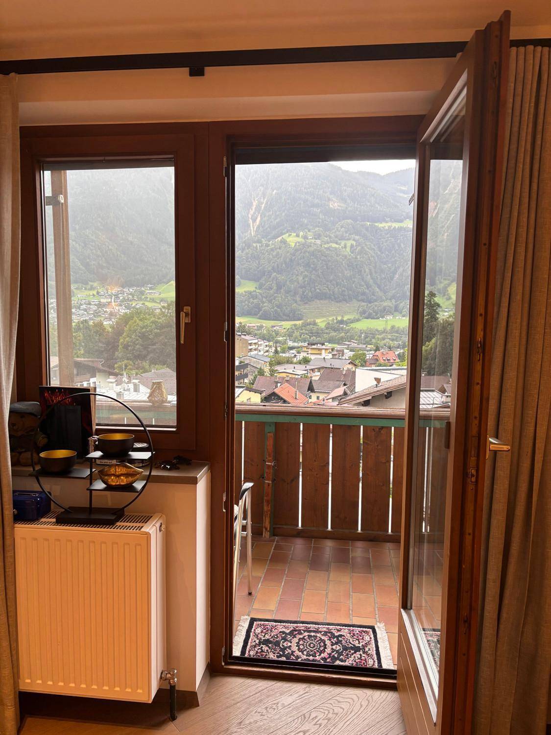 Innenansicht mit Zugang zum Balkon und weitem Blick auf die umliegende Berglandschaft.