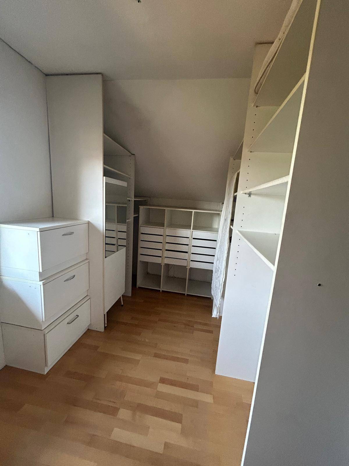 Geräumiger Abstellraum mit Regalsystemen und Dachschräge, ideal für zusätzlichen Stauraum.