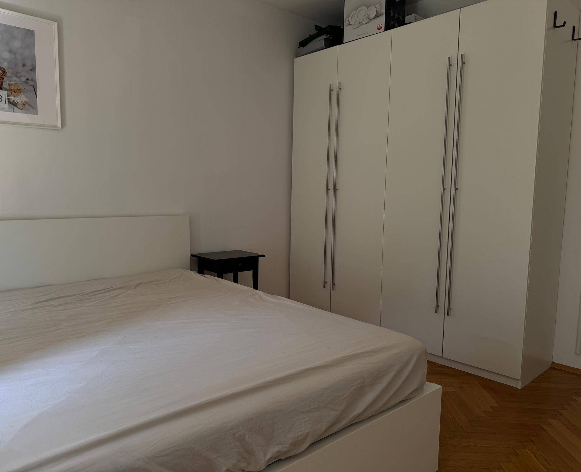 Schlafzimmer mit großem Bett und geräumigen weißen Kleiderschränken, bietet viel Stauraum.