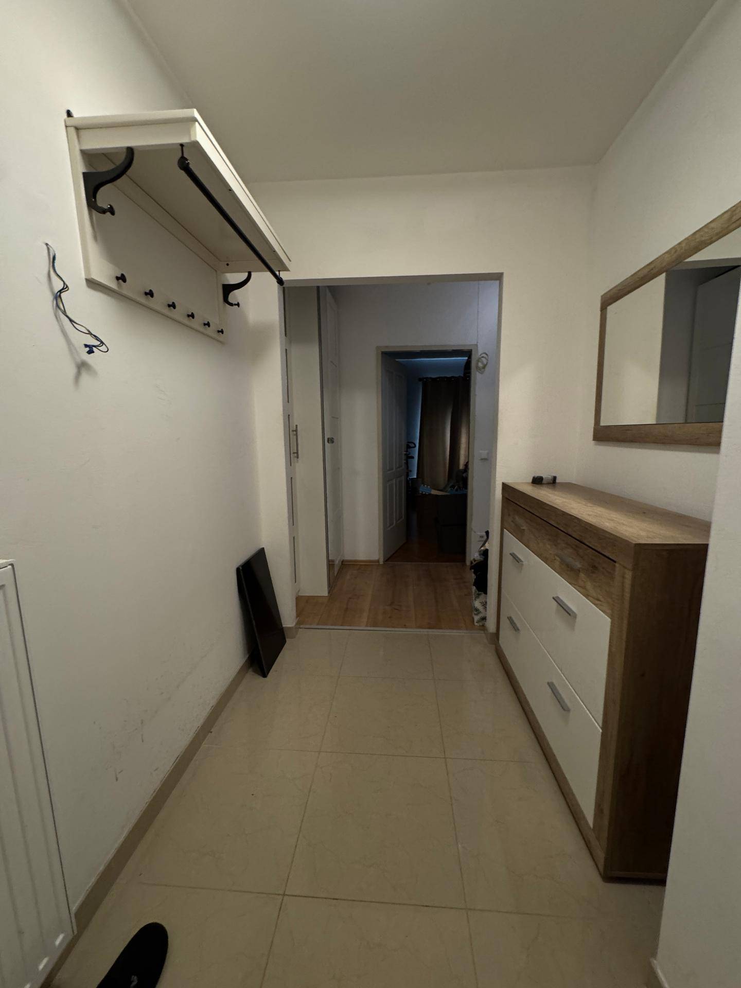 Geräumiger Flur mit Fliesenboden, Garderobe und Kommode, einladender Eingangsbereich.