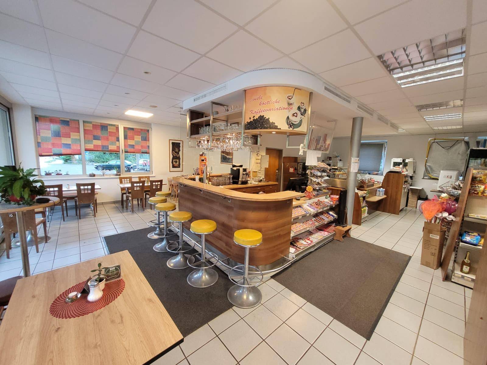 Geräumiger Verkaufsraum mit einer Bar, Hockern und weiteren Sitzgelegenheiten für Kunden.