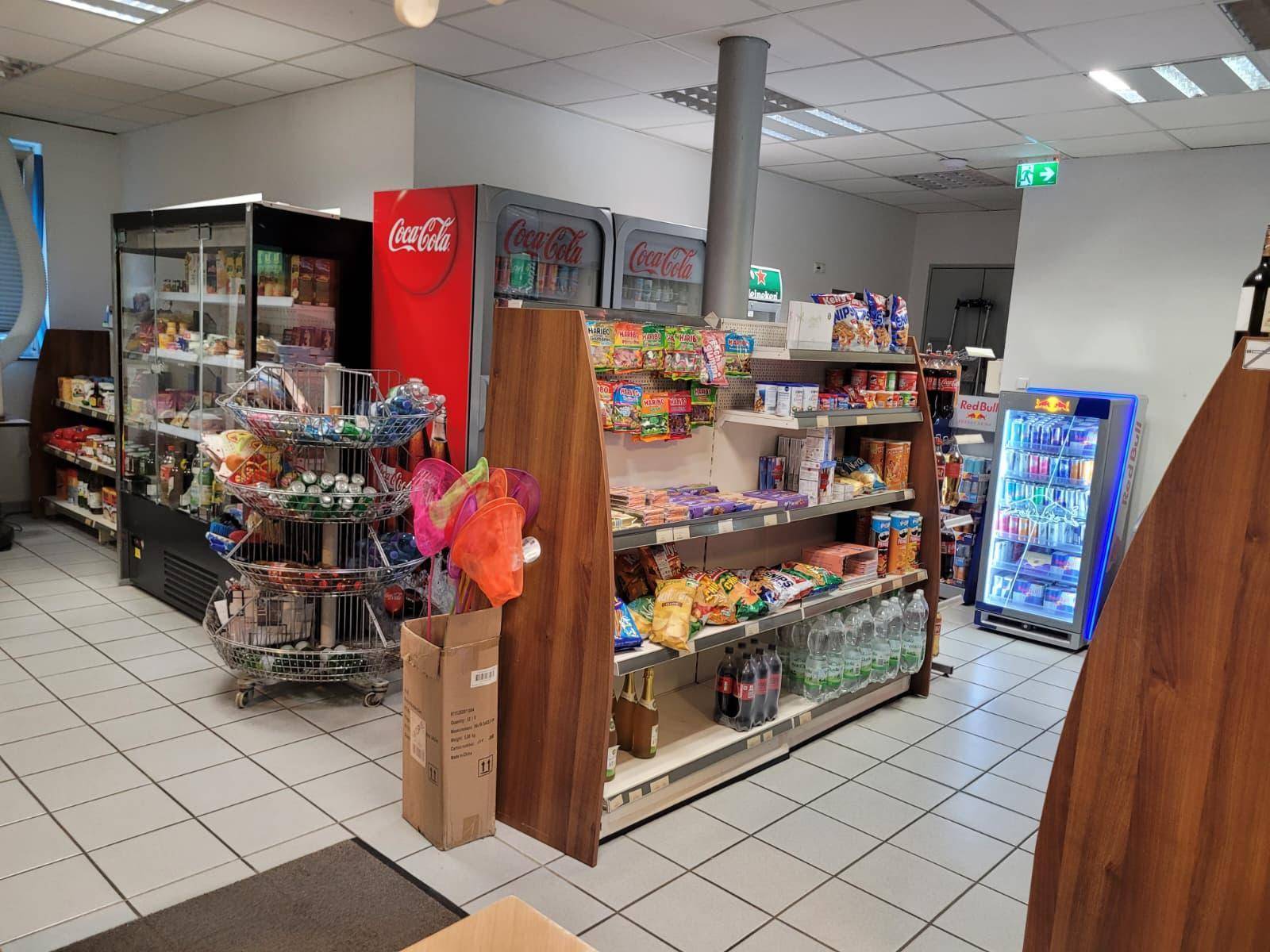 Umfassender Blick auf den Verkaufsraum mit verschiedenen Regalen und Kühlvitrinen für Produkte.