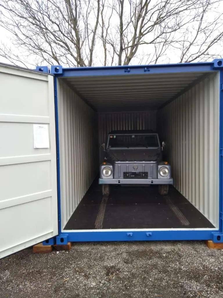Innenansicht eines blauen Schiffscontainers mit einem Fahrzeug darin, ideal zur sicheren Lagerung.