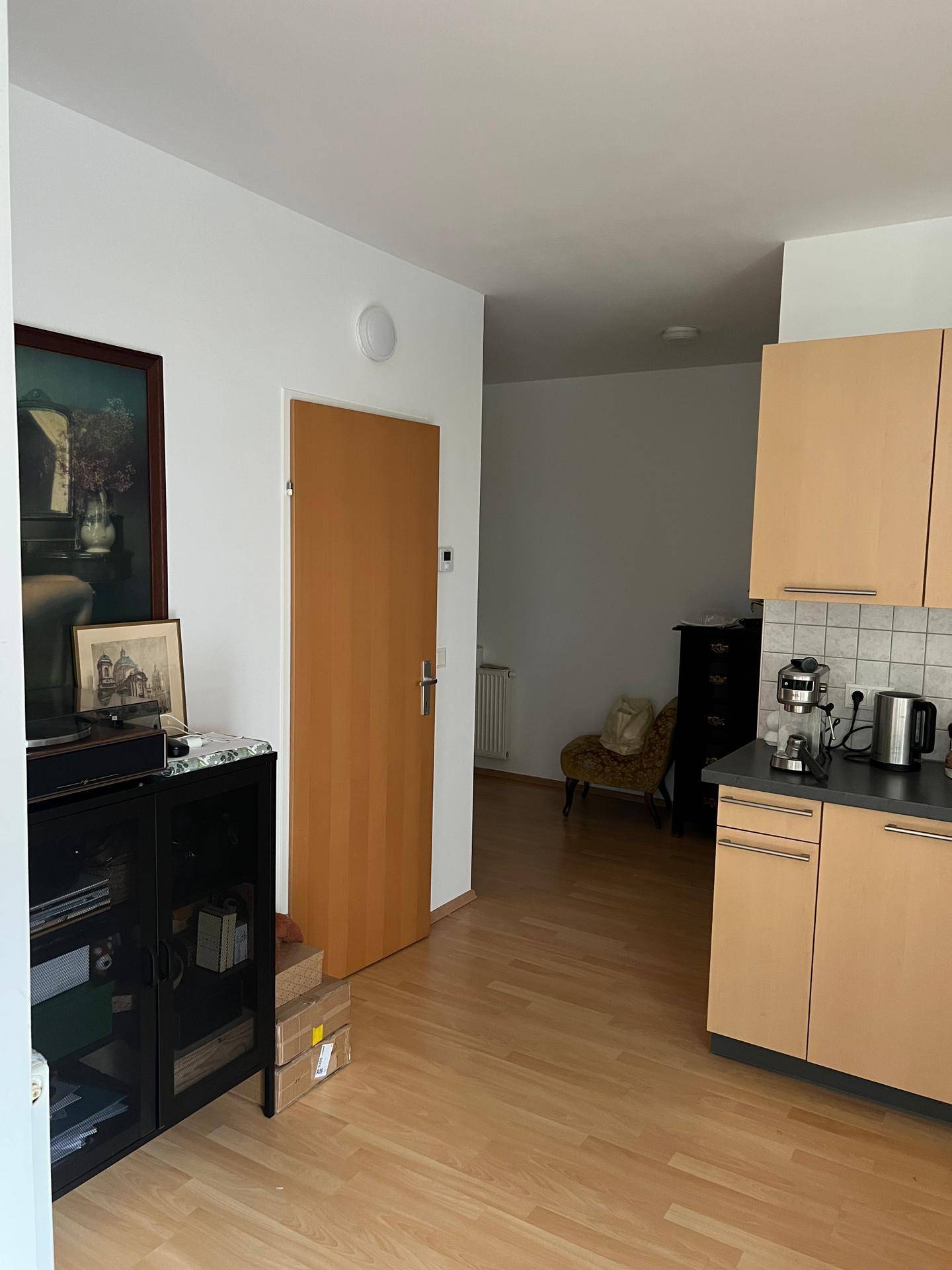 Übergangsbereich von der Küche zu einem Flur mit Holztür und hellem Laminatboden.