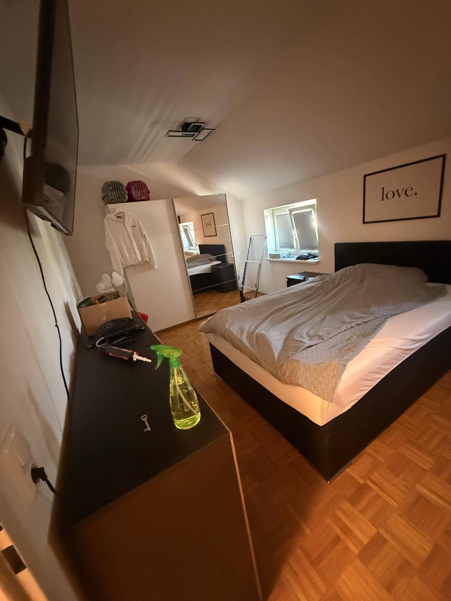 Gemütliches Schlafzimmer mit Doppelbett, Spiegelschrank und Parkettboden.