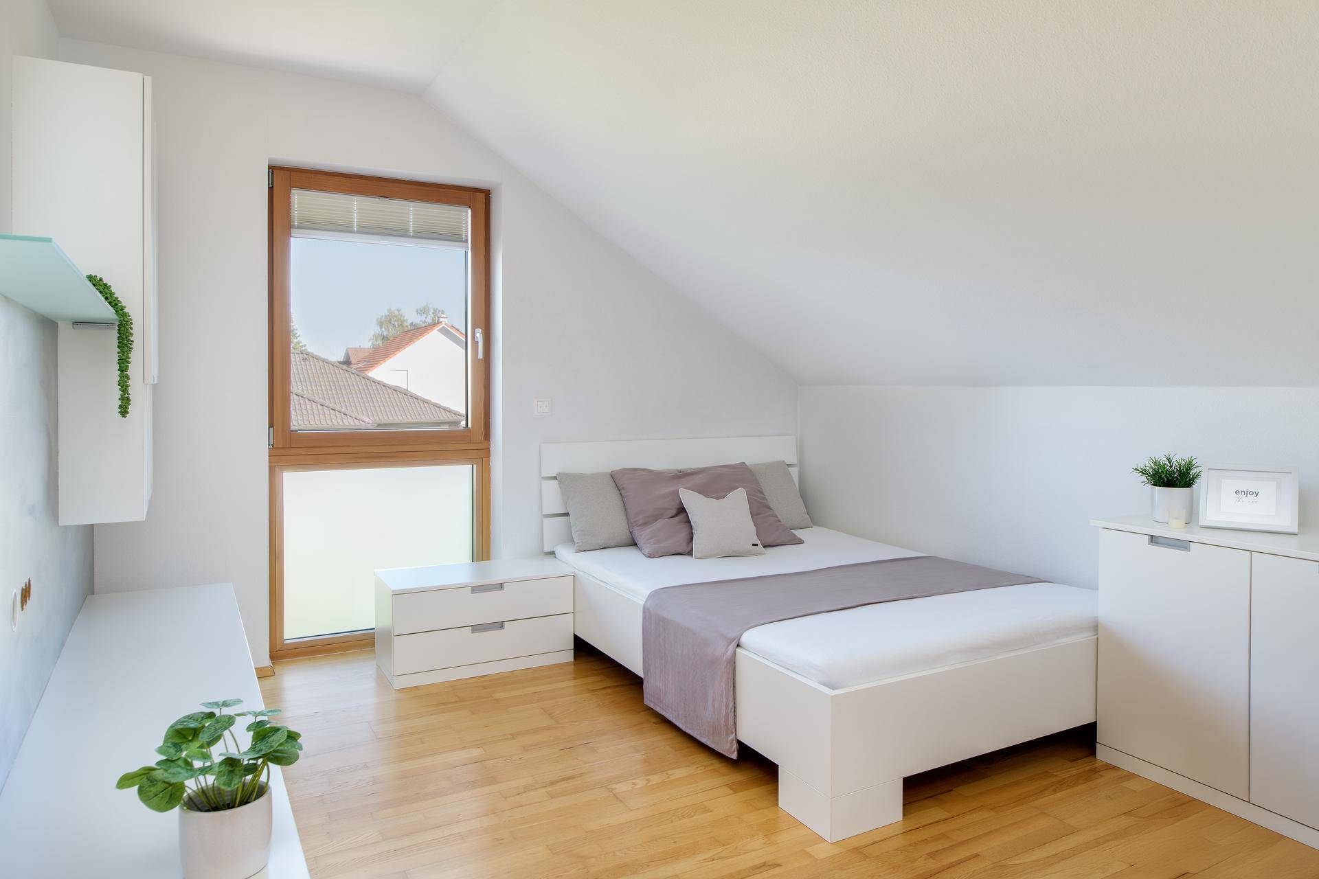 Helles Kinderzimmer im Dachgeschoss mit Einzelbett, Holzboden und Schreibtischbereich.