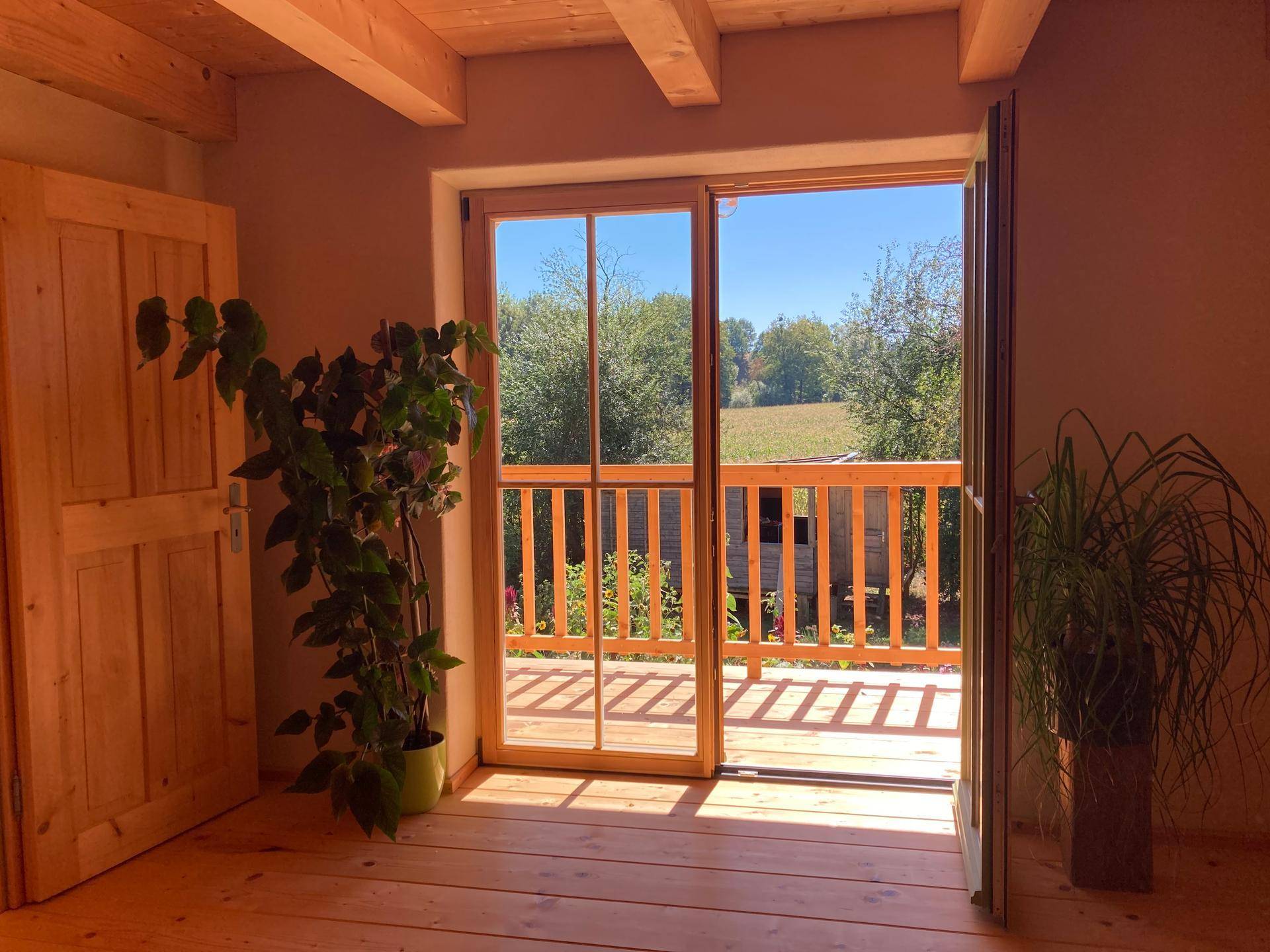 Schlafzimmer mit direktem Zugang zu einem Balkon und weitem Blick in die Natur.