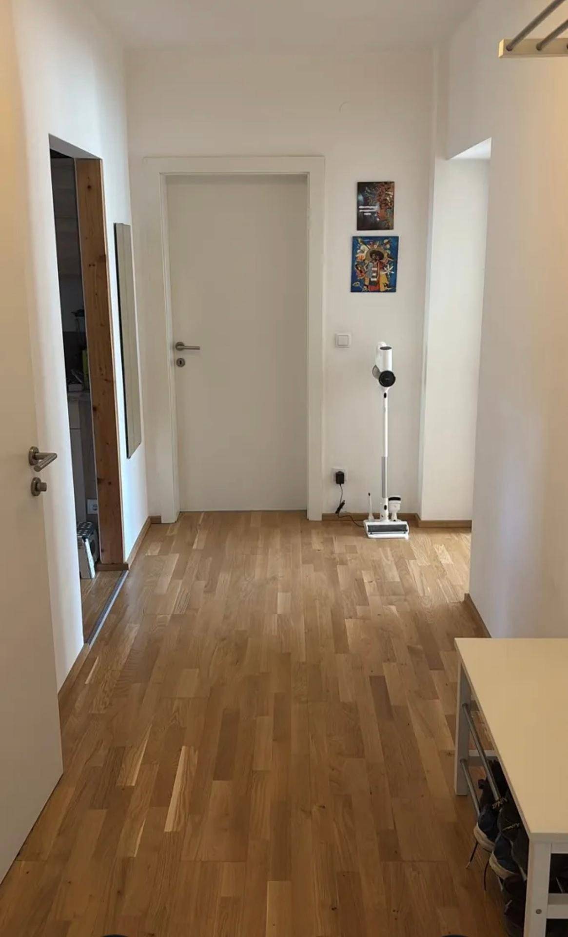 Heller Eingangsbereich mit Holzboden und Platz für eine Garderobe.
