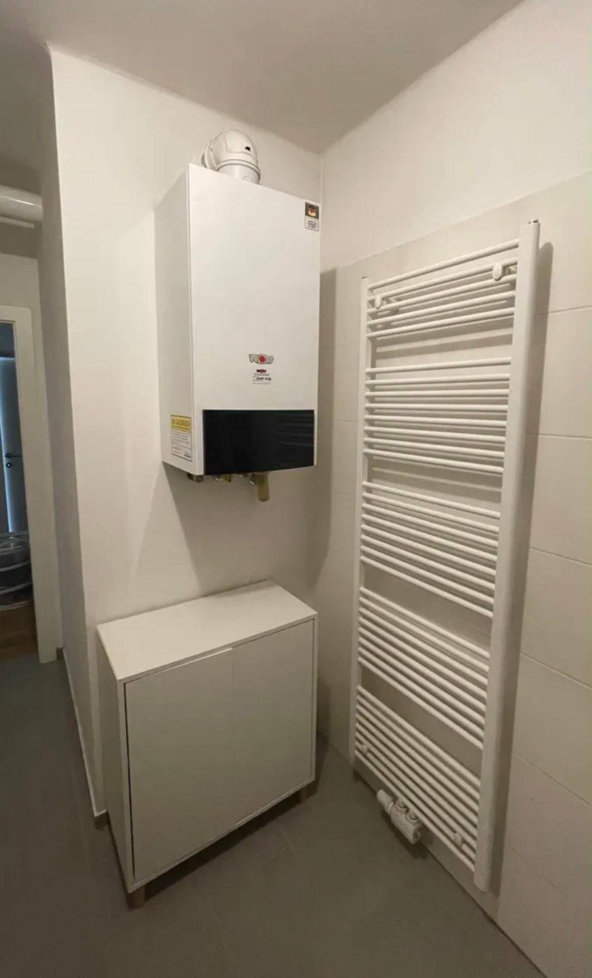 Heizungsraum mit Wandtherme und Handtuchheizkörper.