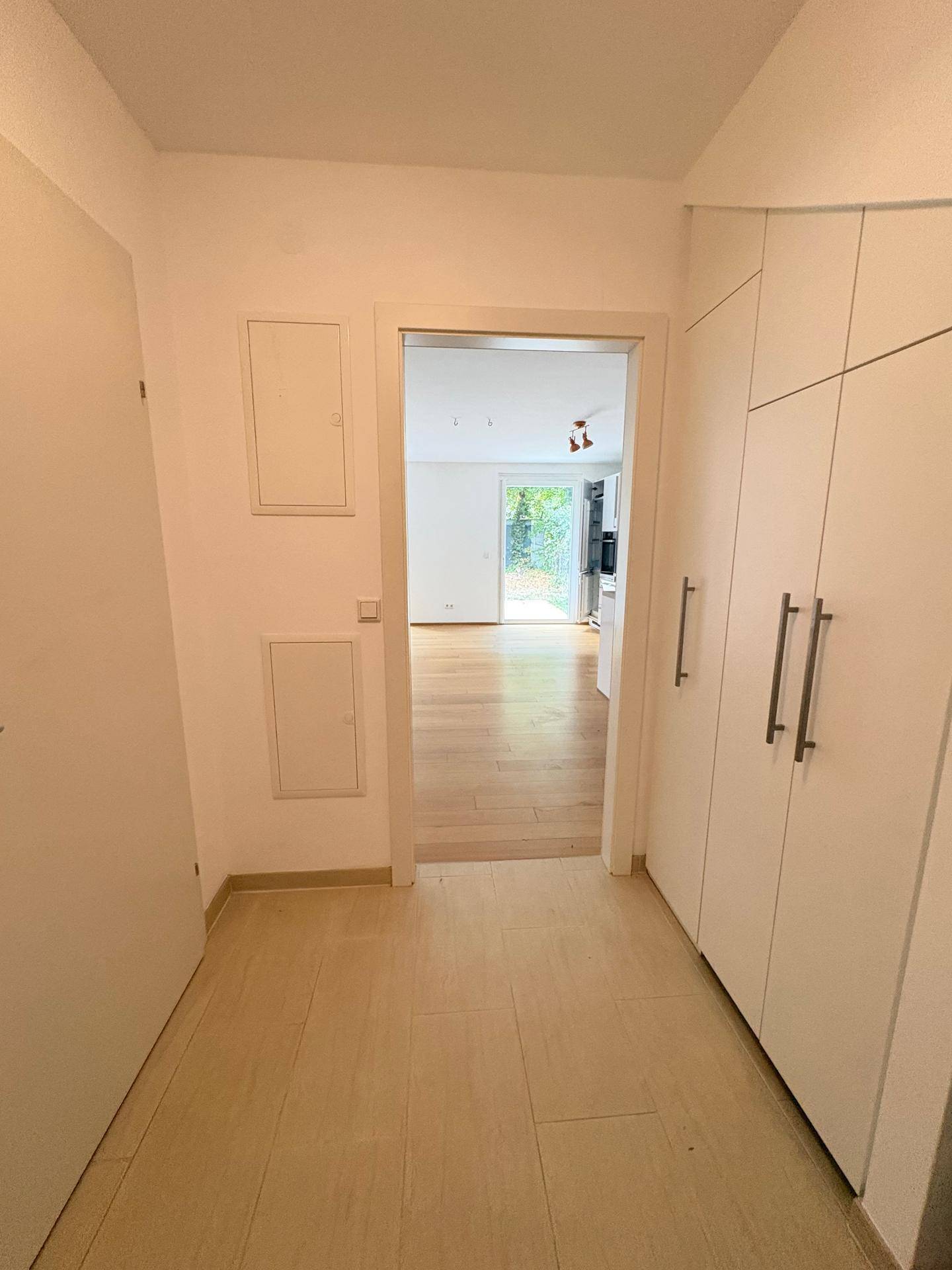 Heller Eingangsbereich mit praktischen Einbauschränken und Blick in den offenen Wohnbereich.