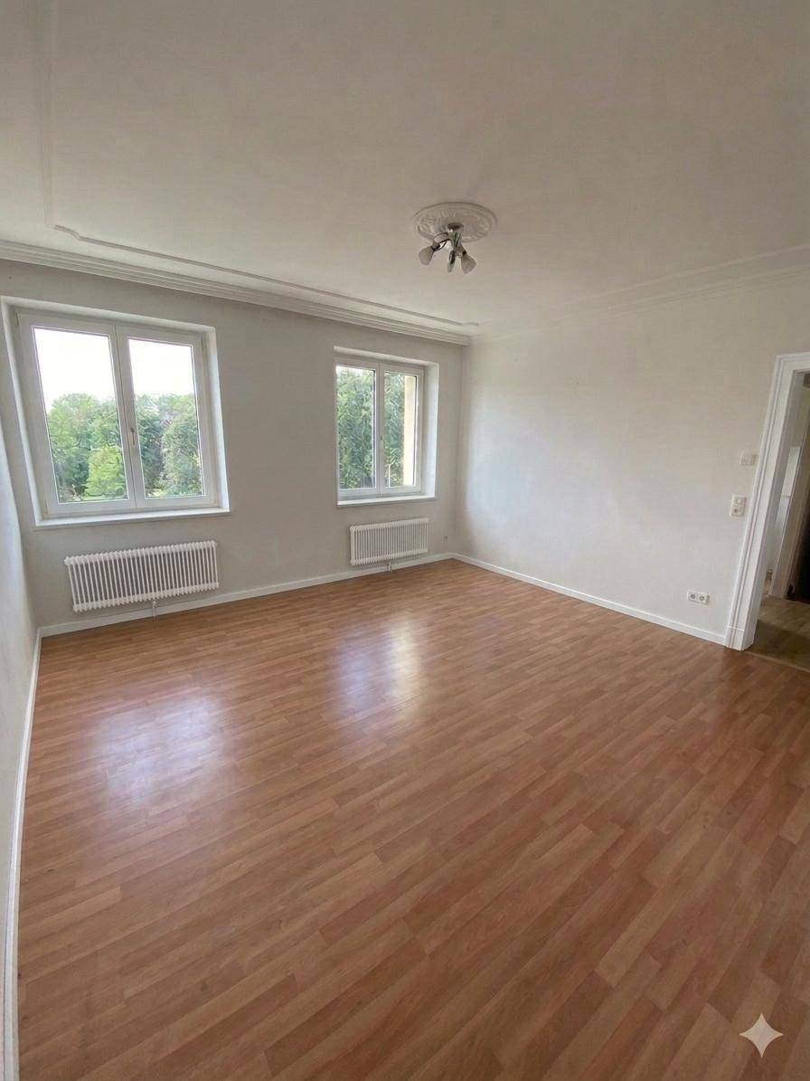 Helles, leeres Zimmer mit Holzboden und zwei großen Fenstern, ideal als Kinderzimmer nutzbar.