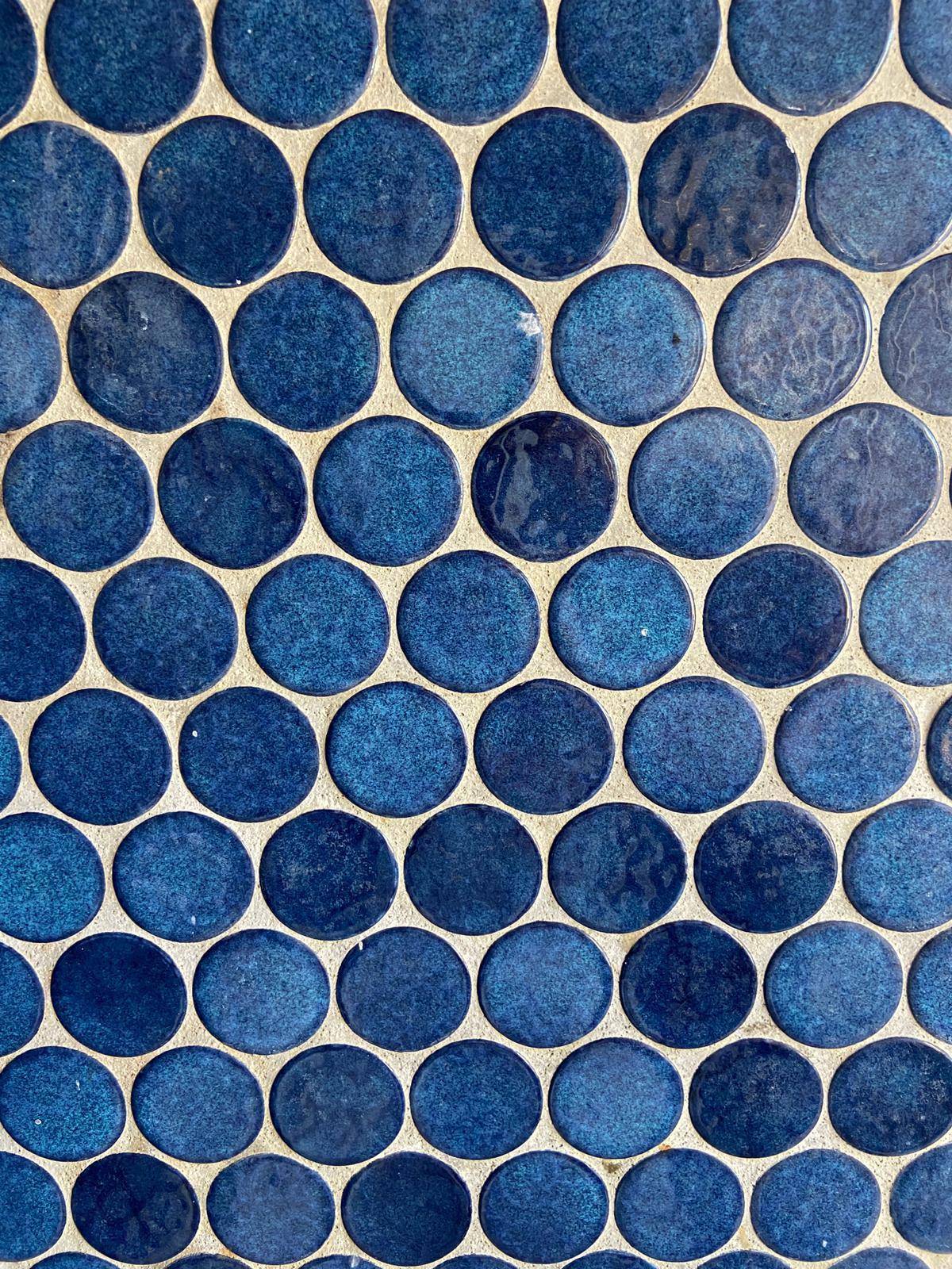 Detailaufnahme von blauen, sechseckigen Mosaikfliesen, die dem Badezimmer Charakter verleihen.