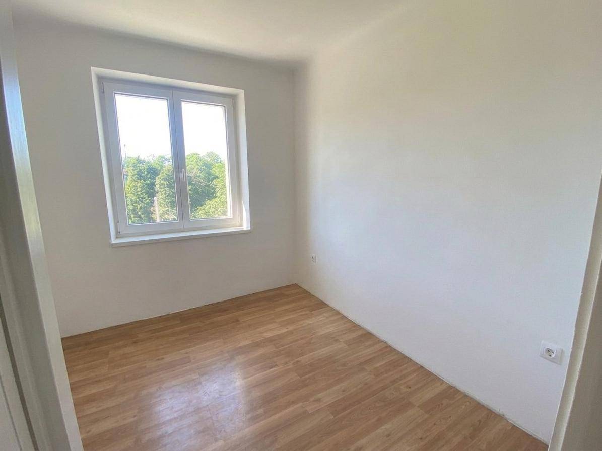 Kleines, helles Zimmer mit Holzboden und Fenster, ideal als Gästezimmer oder Büro nutzbar.