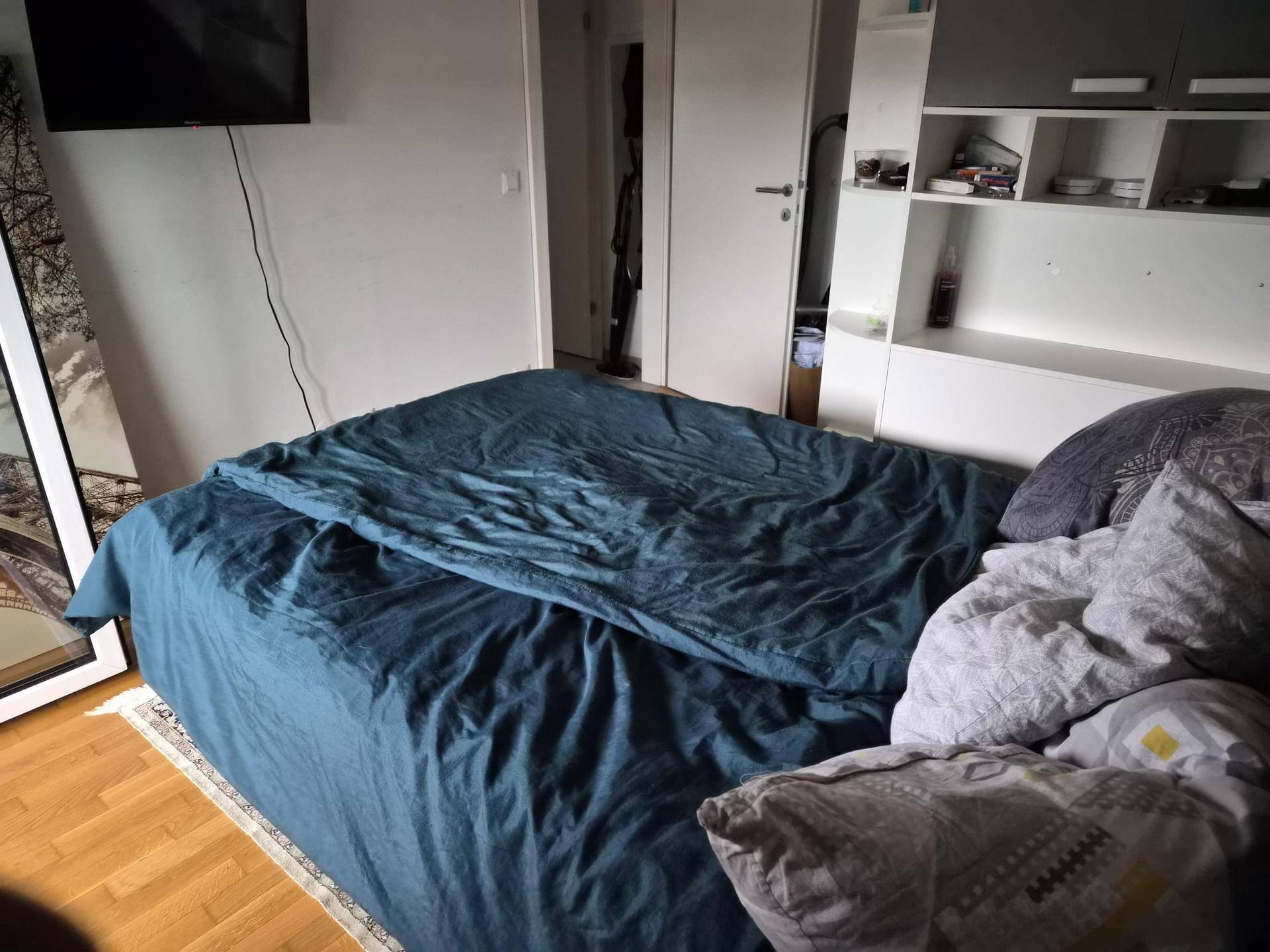 Nahaufnahme eines Doppelbettes in einem Schlafzimmer mit Holzboden und modernen Möbeln.