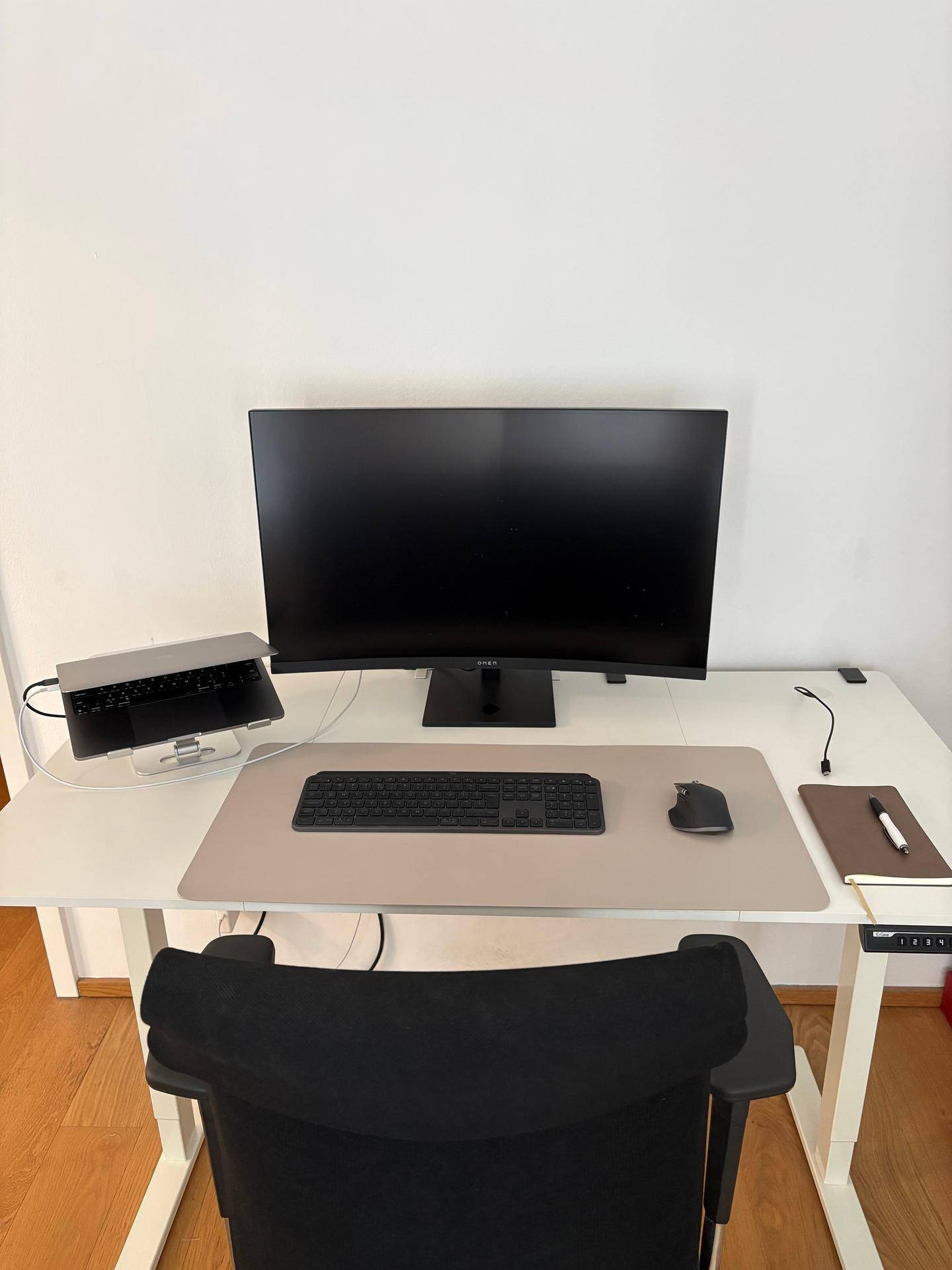 Funktionaler Arbeitsbereich mit modernem Schreibtisch, Monitor und ergonomischem Stuhl.