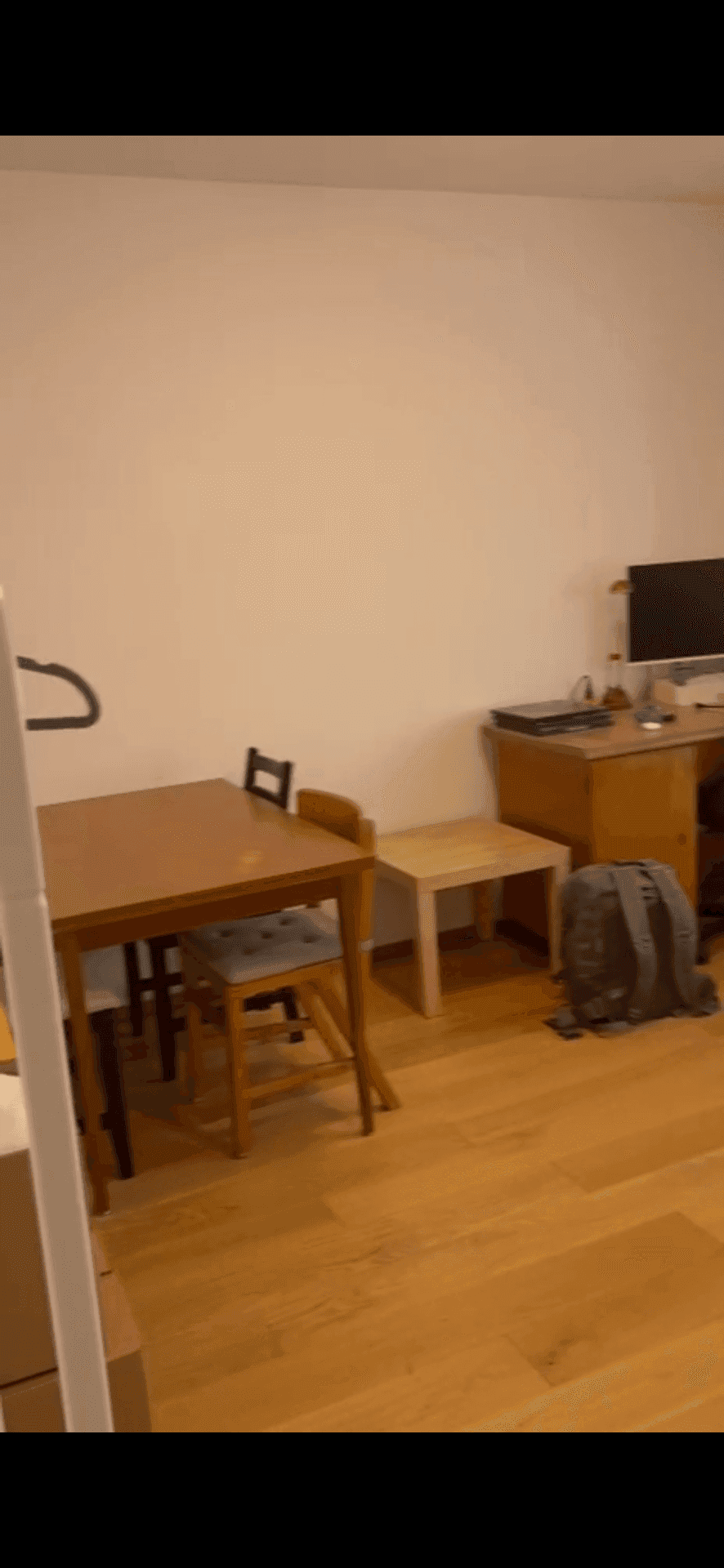 Essbereich mit Holztisch und Stühlen, daneben ein Arbeitsplatz im Hintergrund.