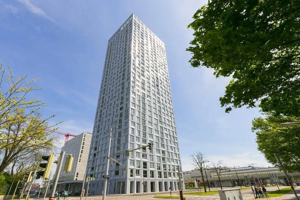 Moderner Wolkenkratzer mit markanter Architektur und vielen Fenstern in urbaner Umgebung.