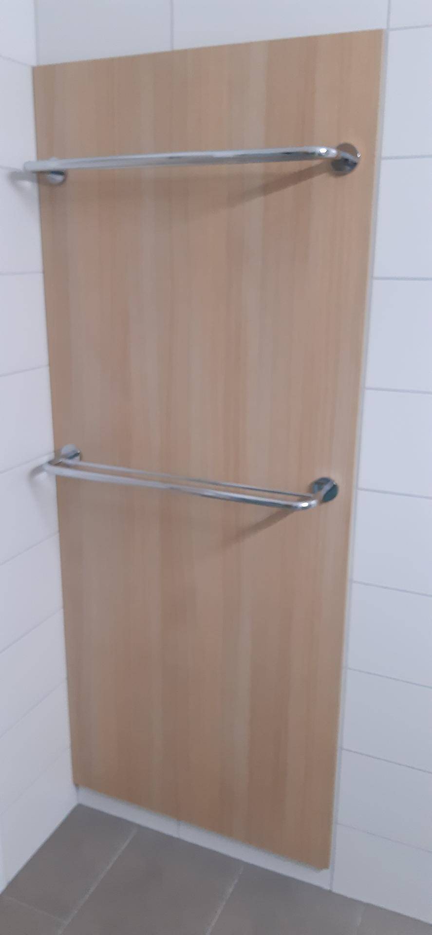 Holzwandpaneel mit zwei Handtuchhaltern, passend für ein modernes Badezimmer oder einen Hauswirtschaftsraum.