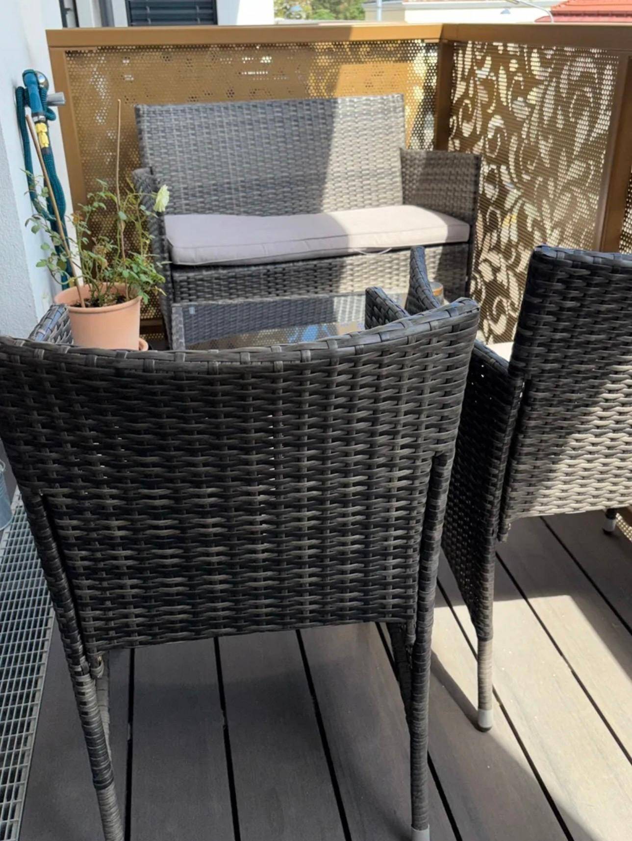 Gemütlicher Balkon mit Rattanmöbeln und dekorativer Sichtschutzwand für entspannte Stunden im Freien.