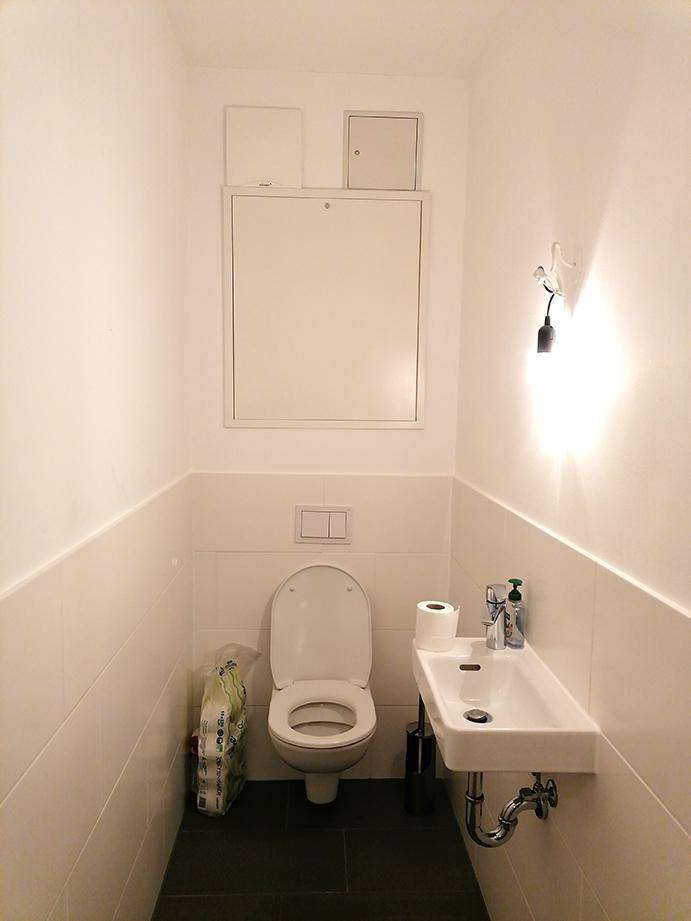 Separates Gäste-WC mit Wand-WC und kleinem Waschbecken.