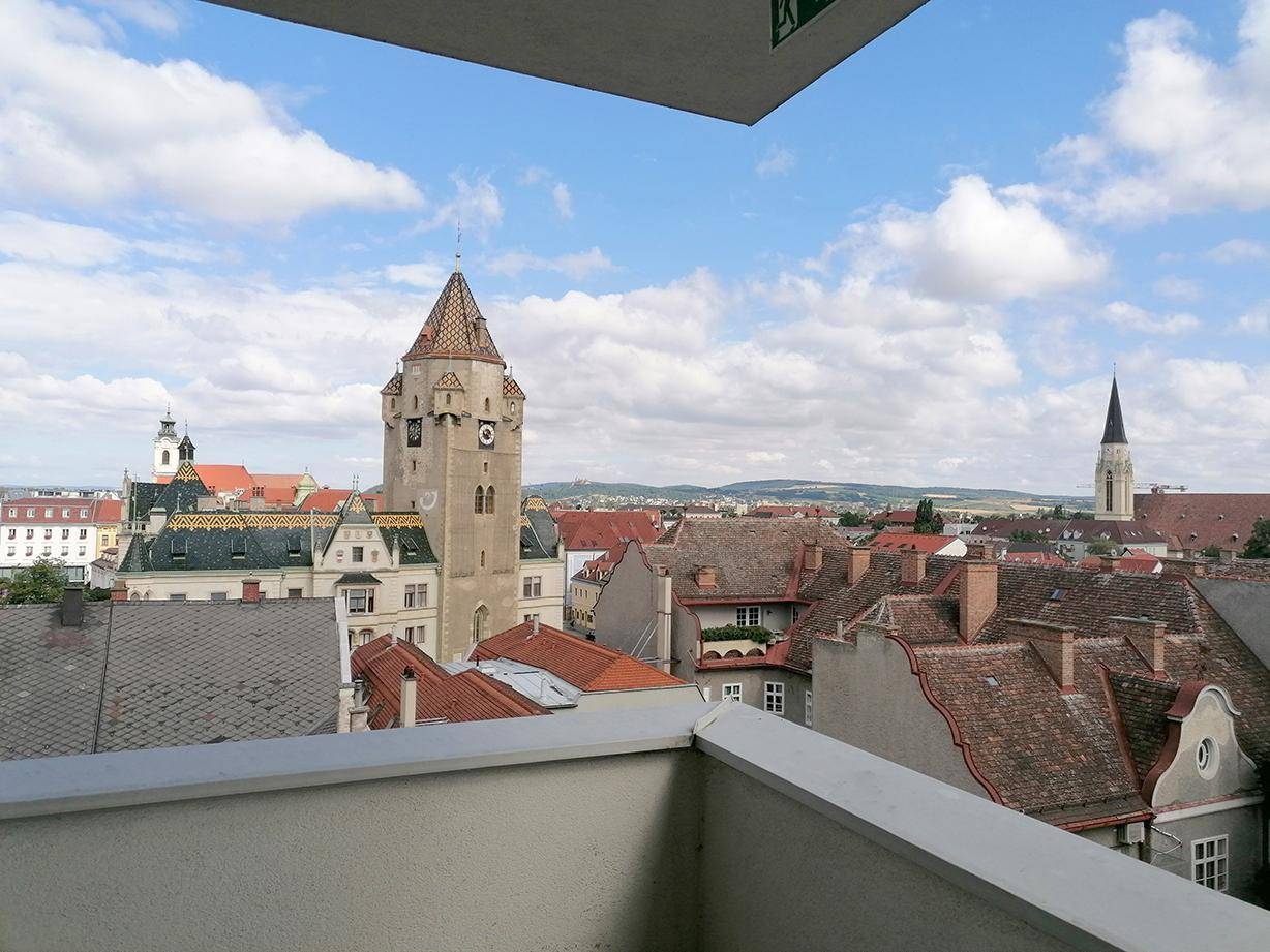 Panoramablick vom Balkon über die historische Stadt mit Kirchturm und Dächern.
