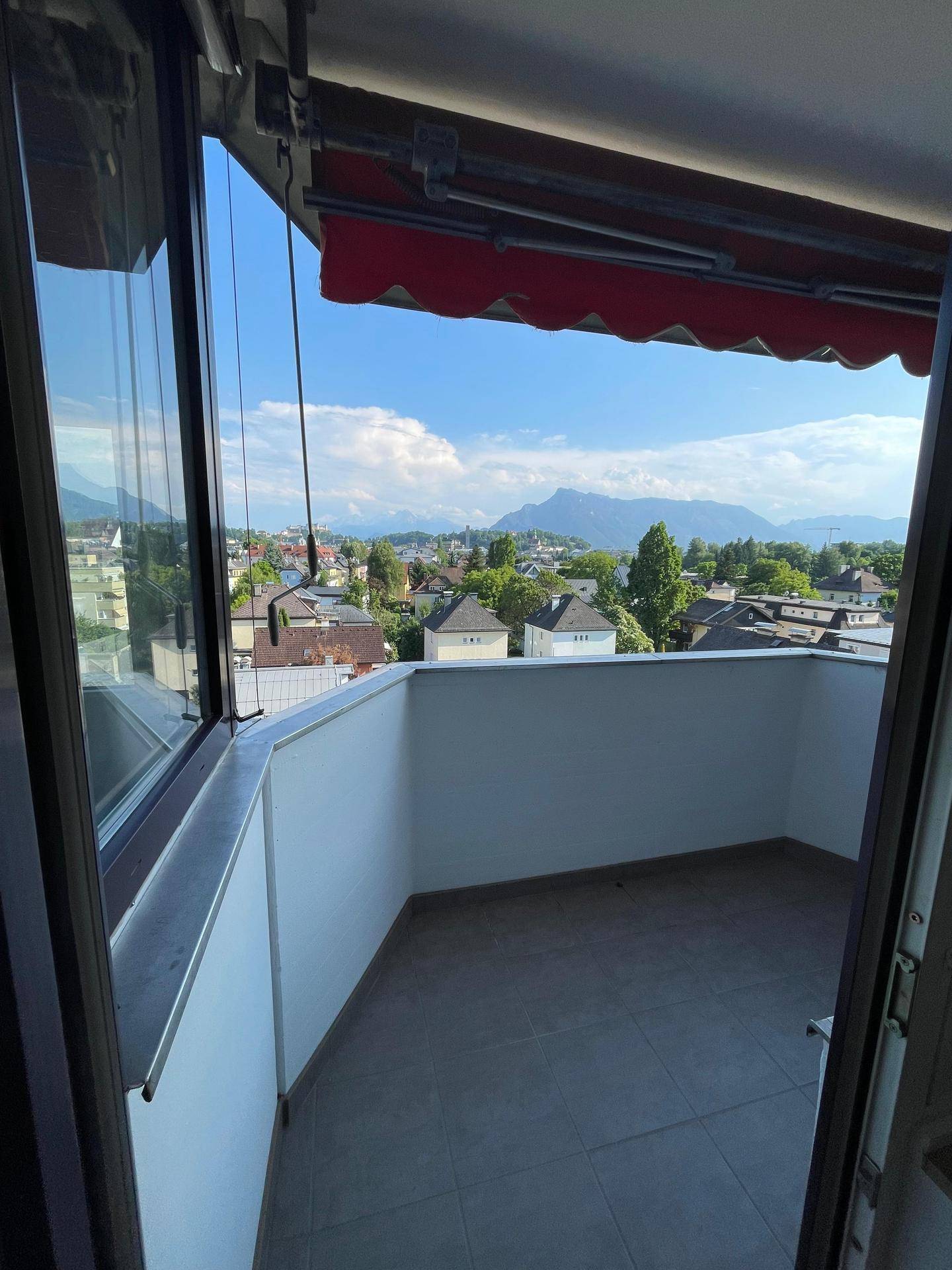 Heller Balkon mit schöner Aussicht auf die Berge und die umliegende Stadtlandschaft.
