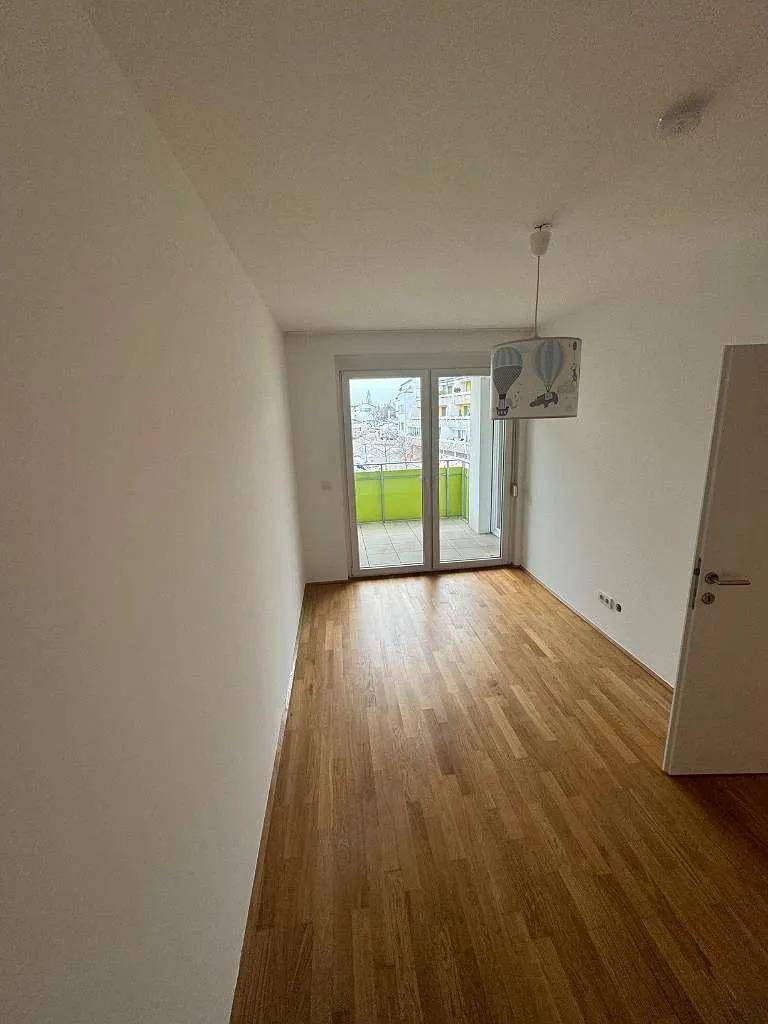 Helles Schlafzimmer mit Parkettboden und direktem Zugang zu einem privaten Balkon.
