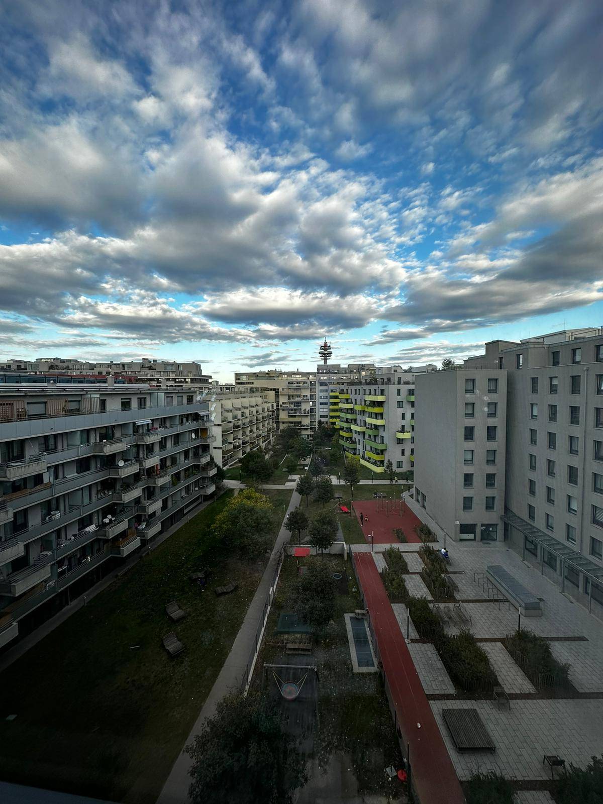Weitläufiger Blick über eine moderne Wohnsiedlung mit Grünflächen und städtischer Architektur.