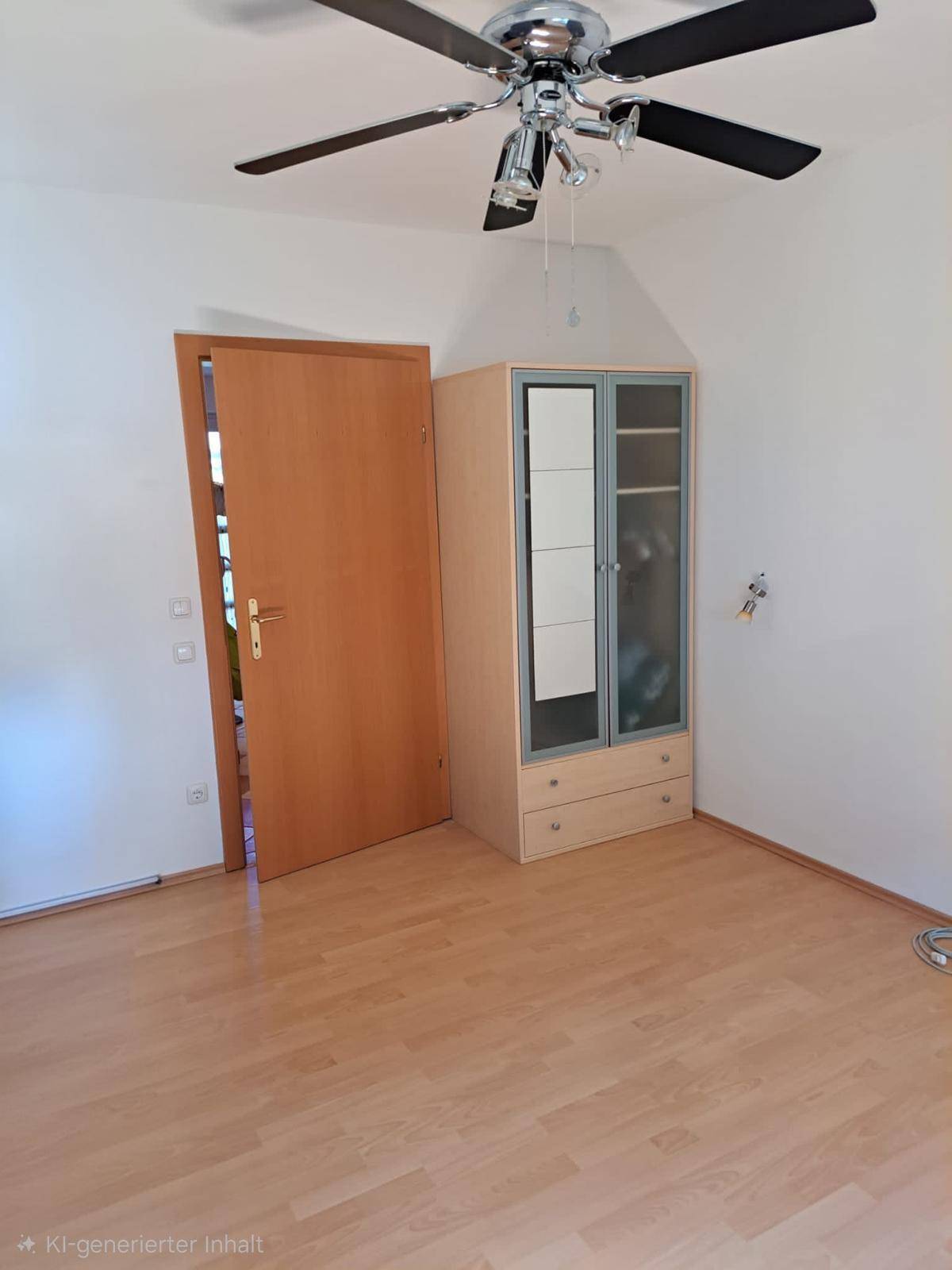 Schlafzimmer mit Laminatboden, Deckenventilator und einem Kleiderschrank.