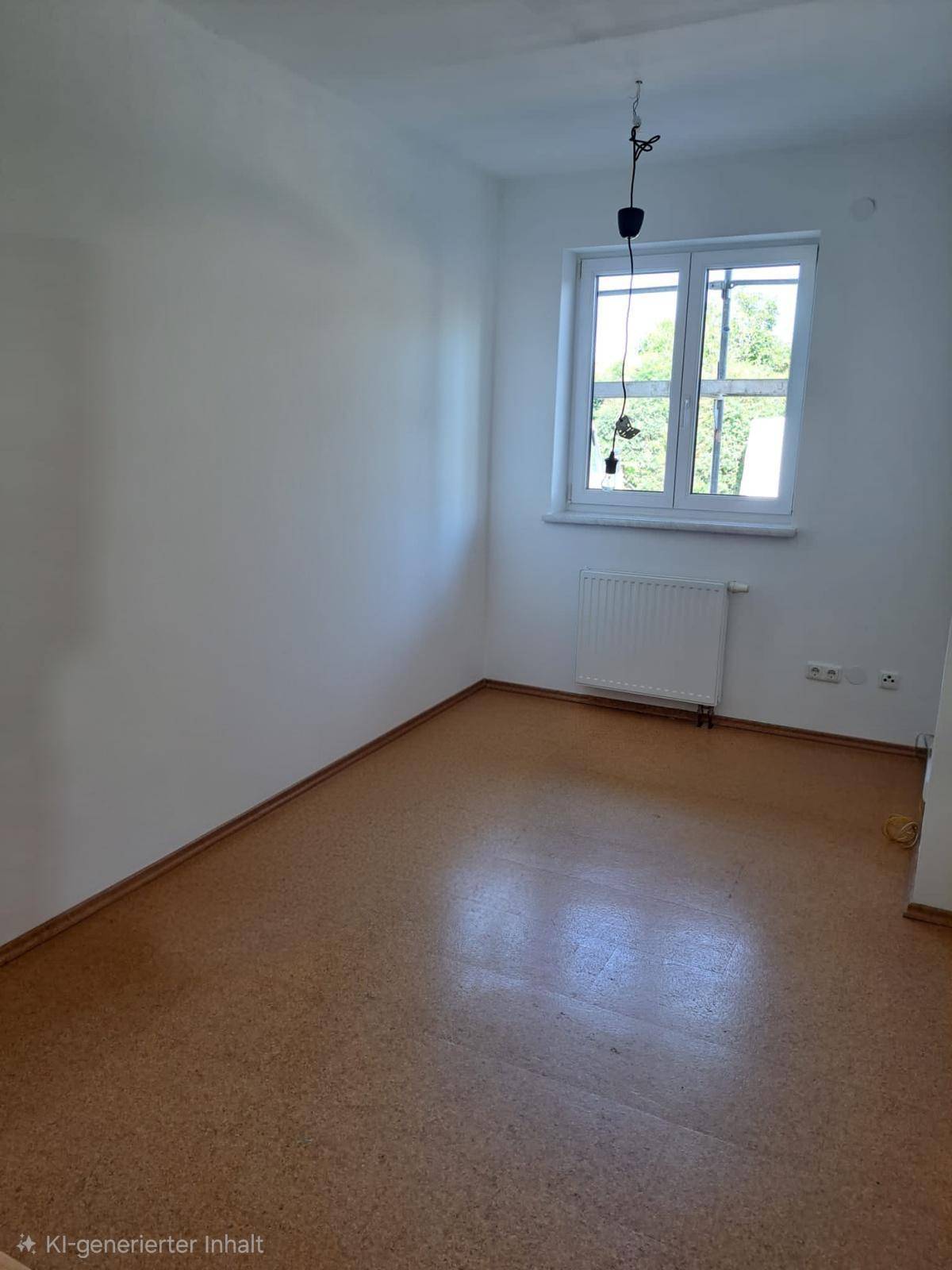 Leeres Zimmer mit Korkboden und großem Fenster, ideal als Schlaf- oder Arbeitszimmer.