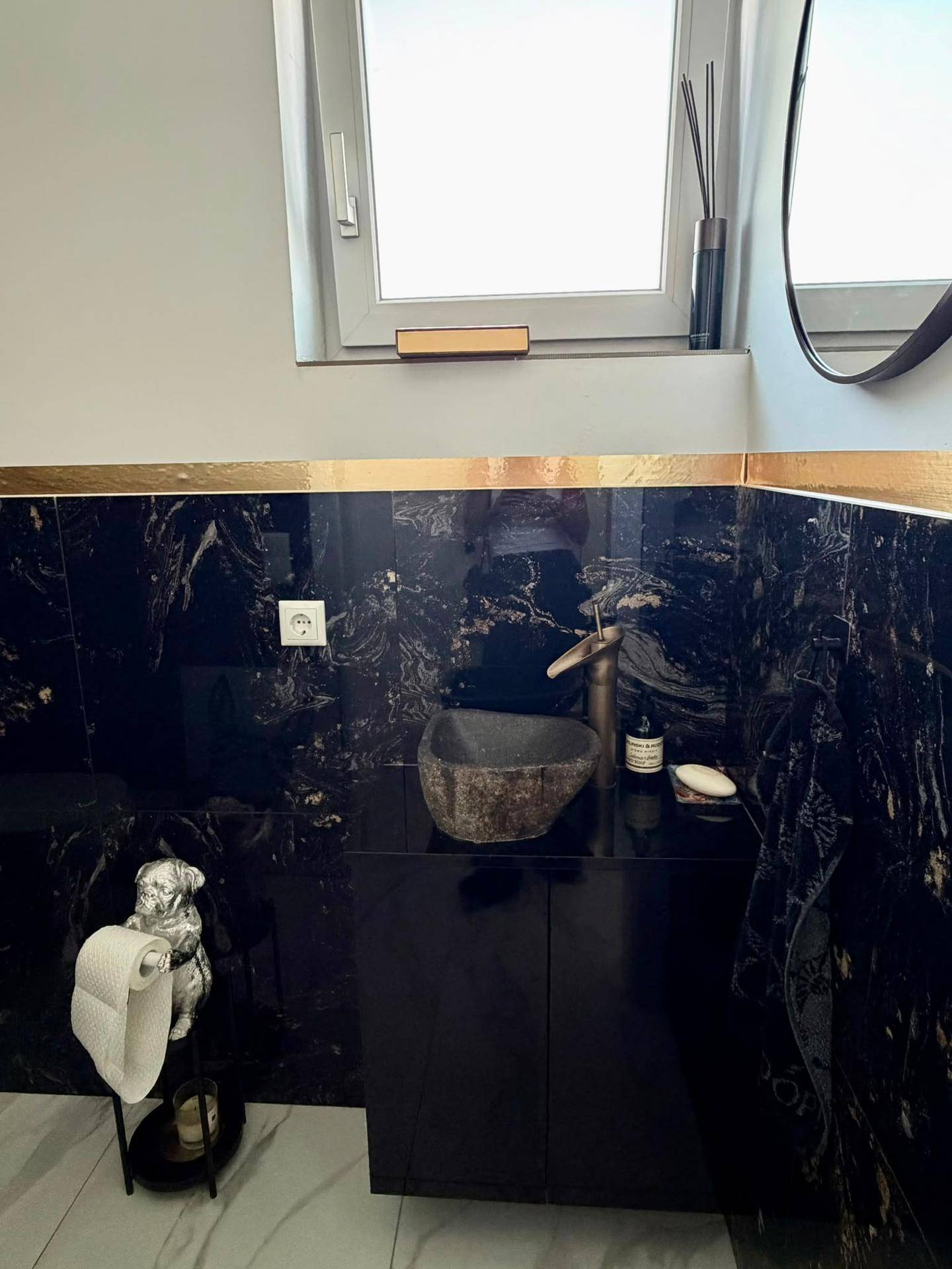 Modernes Gäste-WC mit Fenster, dunklem Waschtisch und einzigartigem Steinwaschbecken.