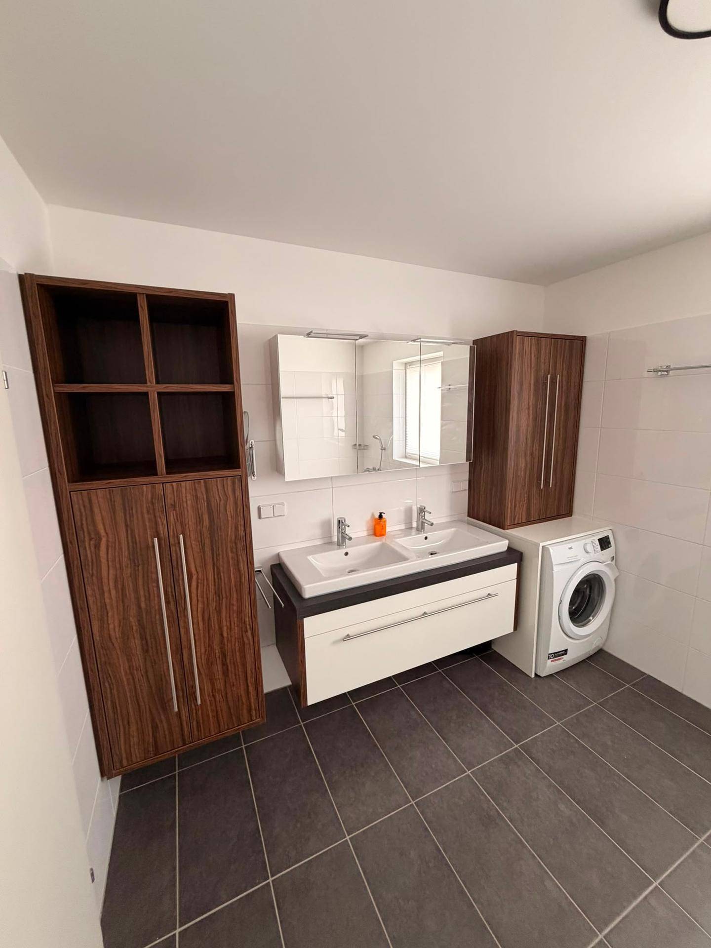 Geräumiges Badezimmer mit Doppelwaschbecken, Spiegelschrank und viel Stauraum.