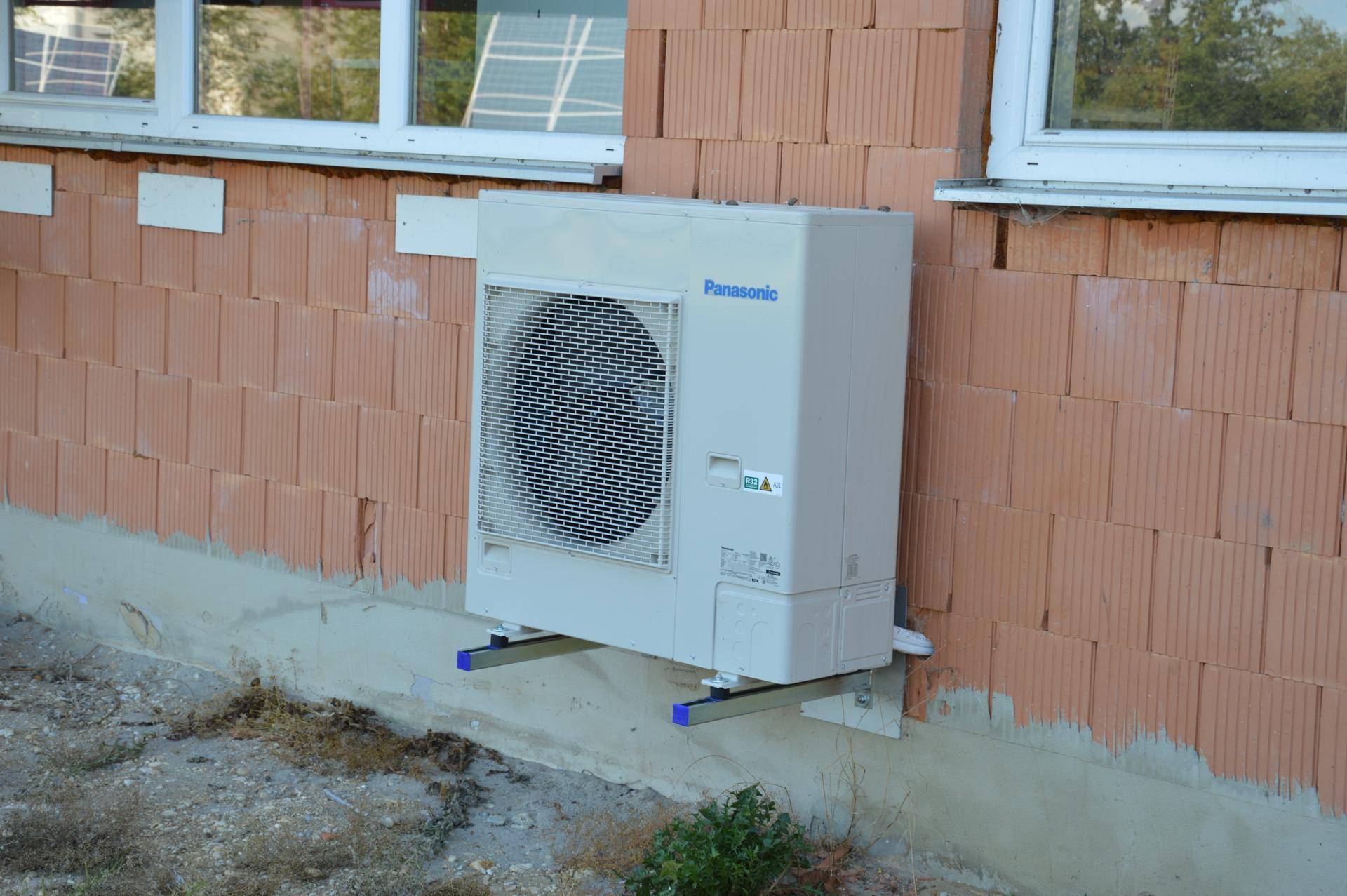 Nahaufnahme einer Panasonic Klimaanlage an einer Ziegelwand, sorgt für angenehme Temperaturen.