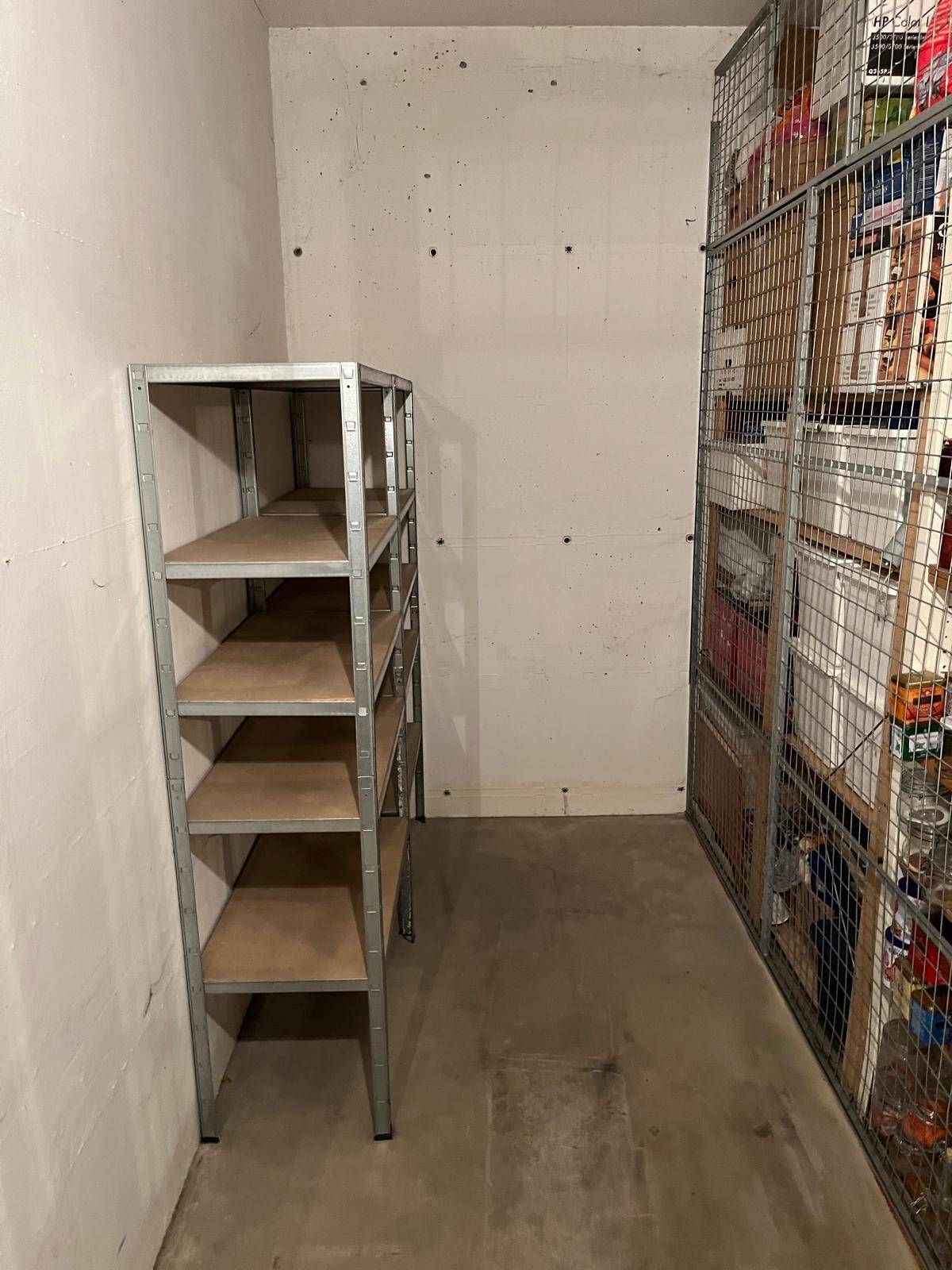 Sauberes Kellerabteil mit Metallregalen, ideal für zusätzlichen Stauraum.