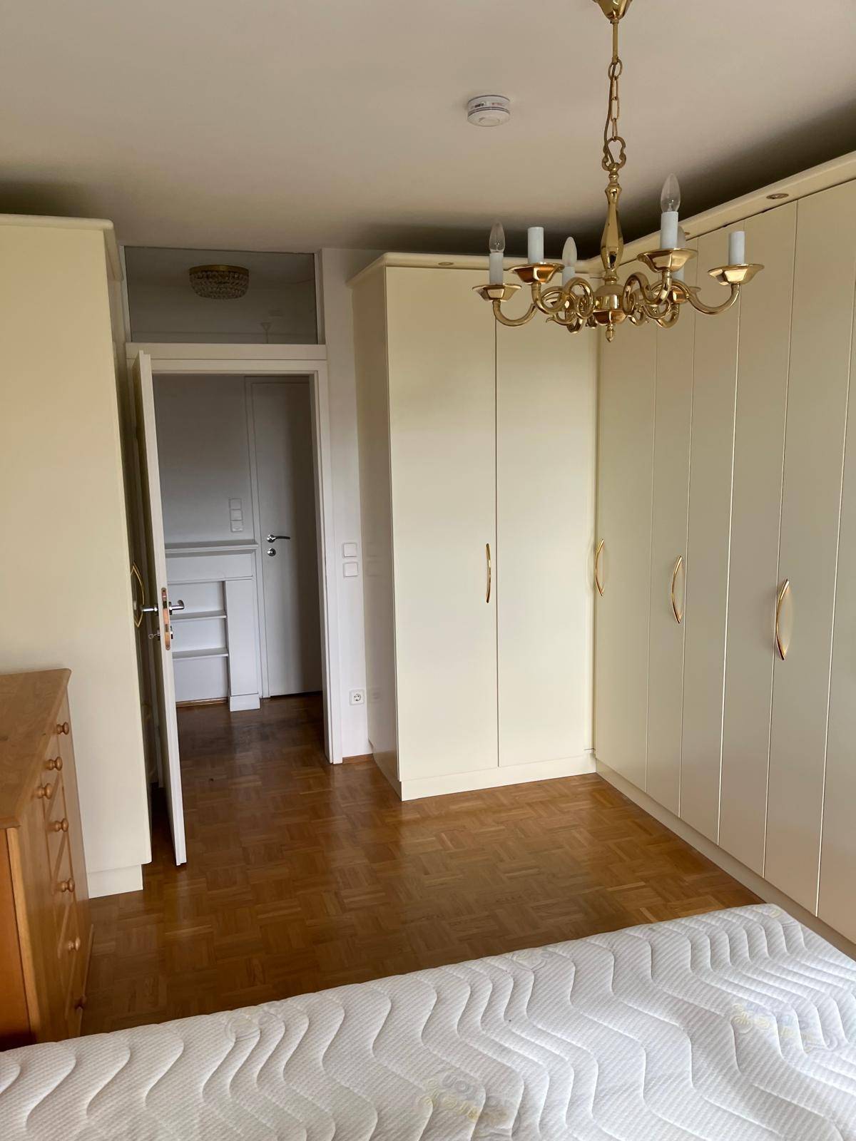 Schlafzimmer mit praktischen Einbauschränken, Holzbett und klassischem Parkettboden.