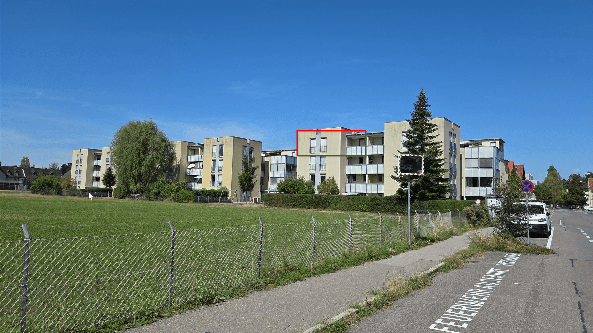 Wohnanlage in grüner Umgebung mit mehreren Gebäuden und weitem Blick.