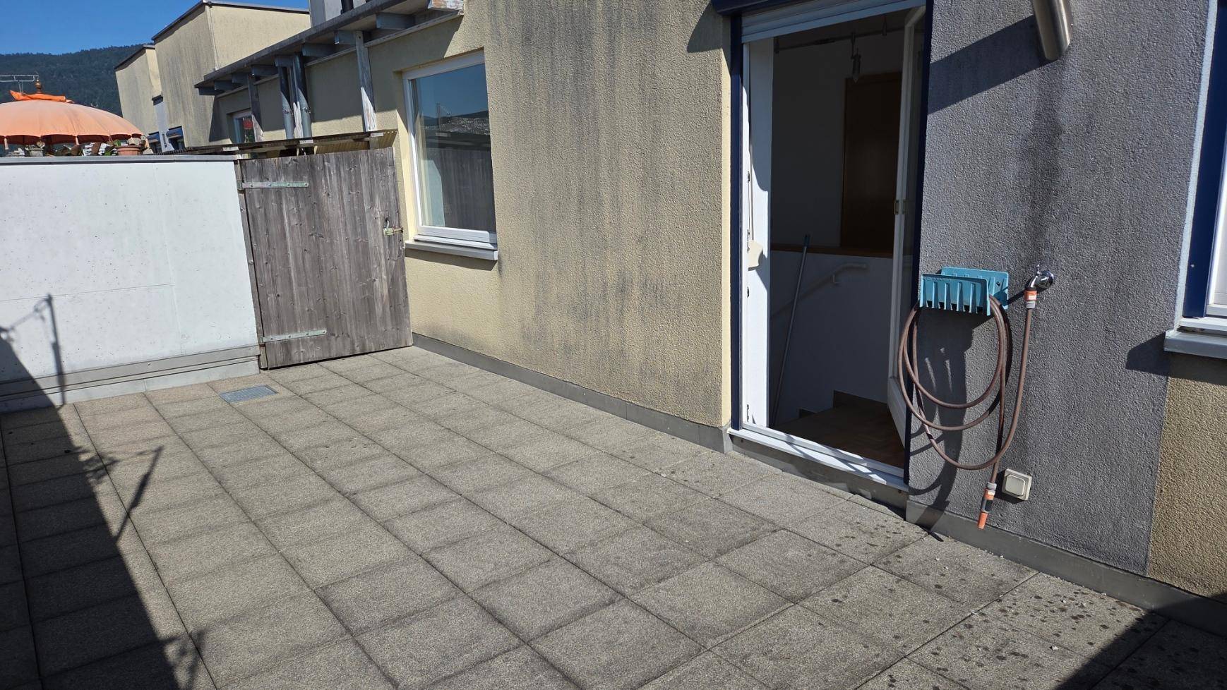Geräumige Dachterrasse mit Fliesenboden und Wasseranschluss, ideal für Entspannung im Freien.