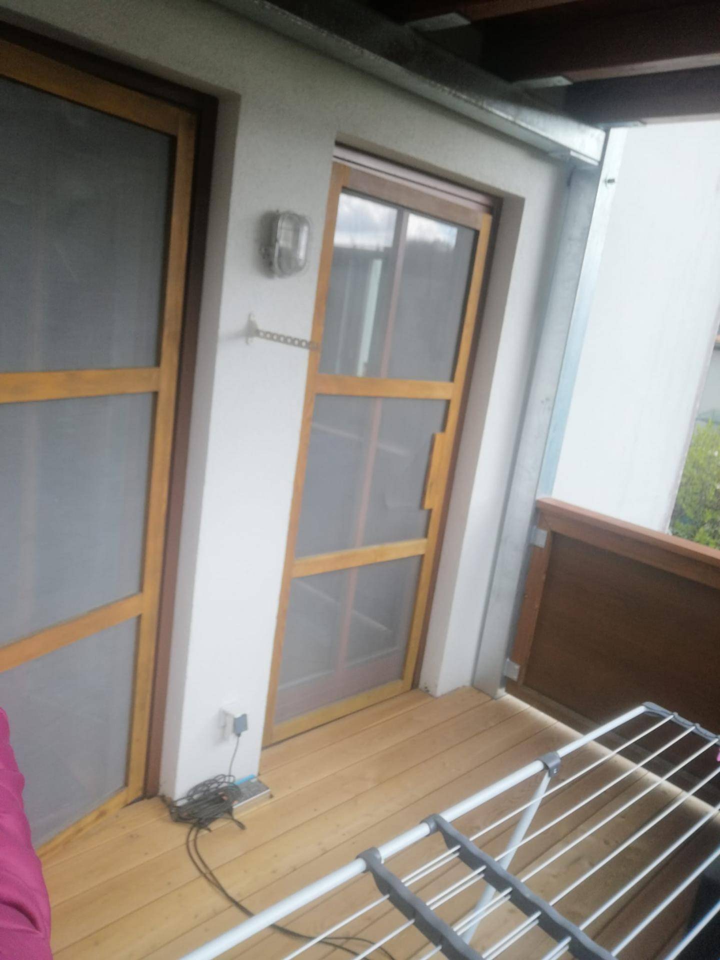 Balkon mit Holzboden und Wäscheständer, bietet praktischen Außenbereich.
