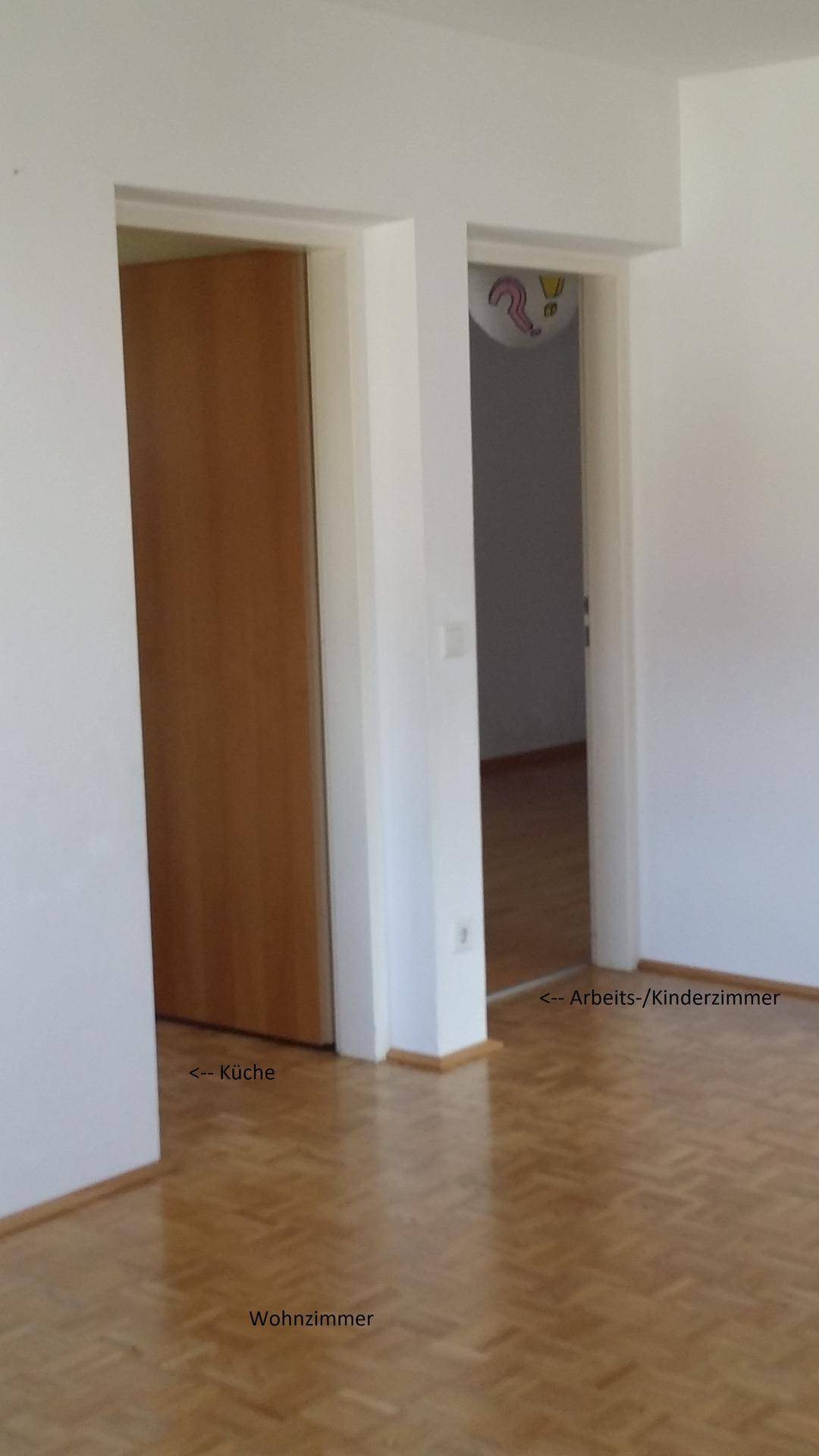 Flur mit Parkettboden und Türen, die zu Küche, Wohnzimmer und Arbeits-/Kinderzimmer führen.