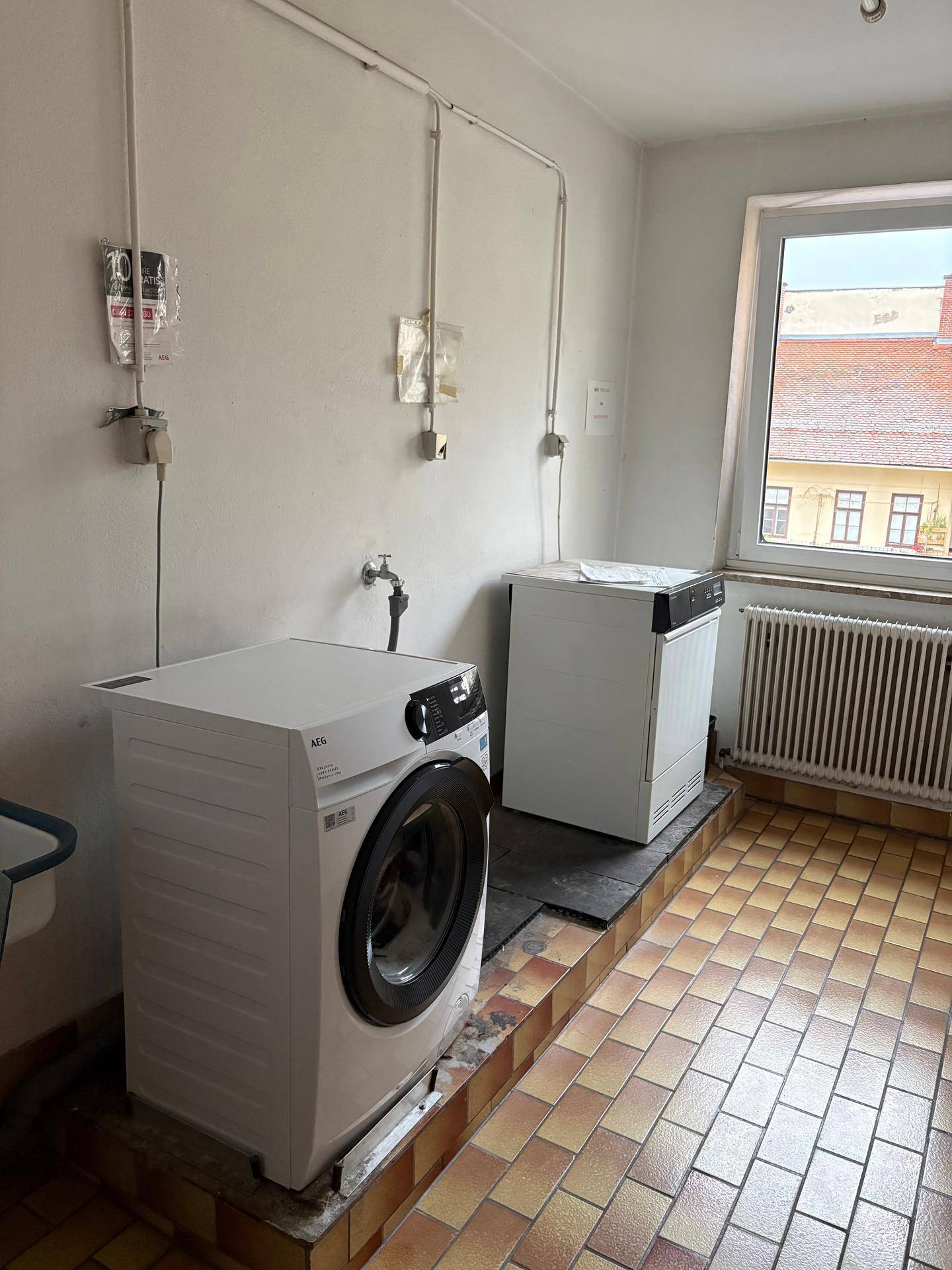 Praktischer Hauswirtschaftsraum mit Waschmaschine, Trockner und einem kleinen Waschbecken.