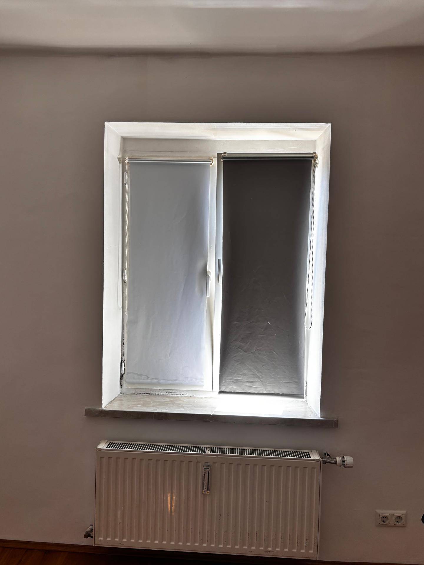 Fenster mit Rollos und einem Heizkörper darunter, bietet Privatsphäre und Wärme.