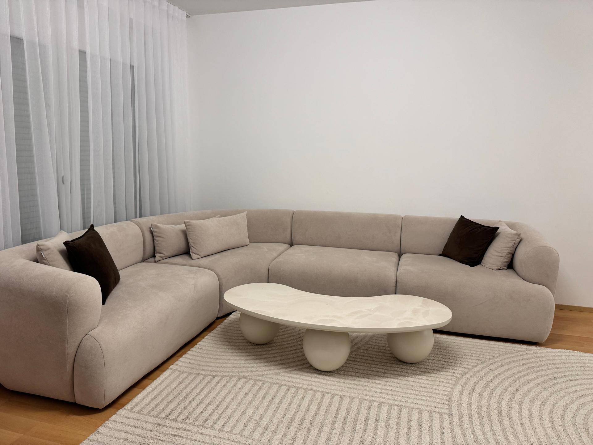 Stilvolles Ecksofa mit beigen Polstern und einem einzigartigen Couchtisch im modernen Wohnzimmer.