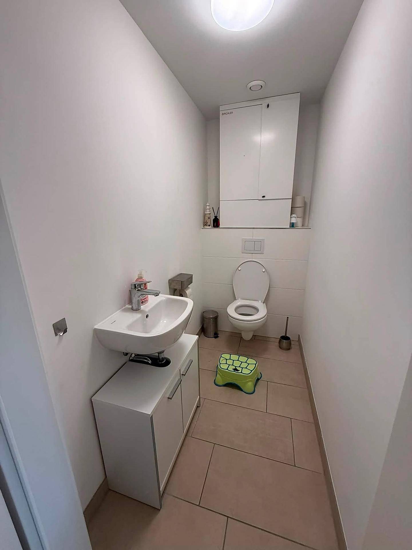 Separates Gäste-WC mit modernem Waschbecken und Wand-WC.