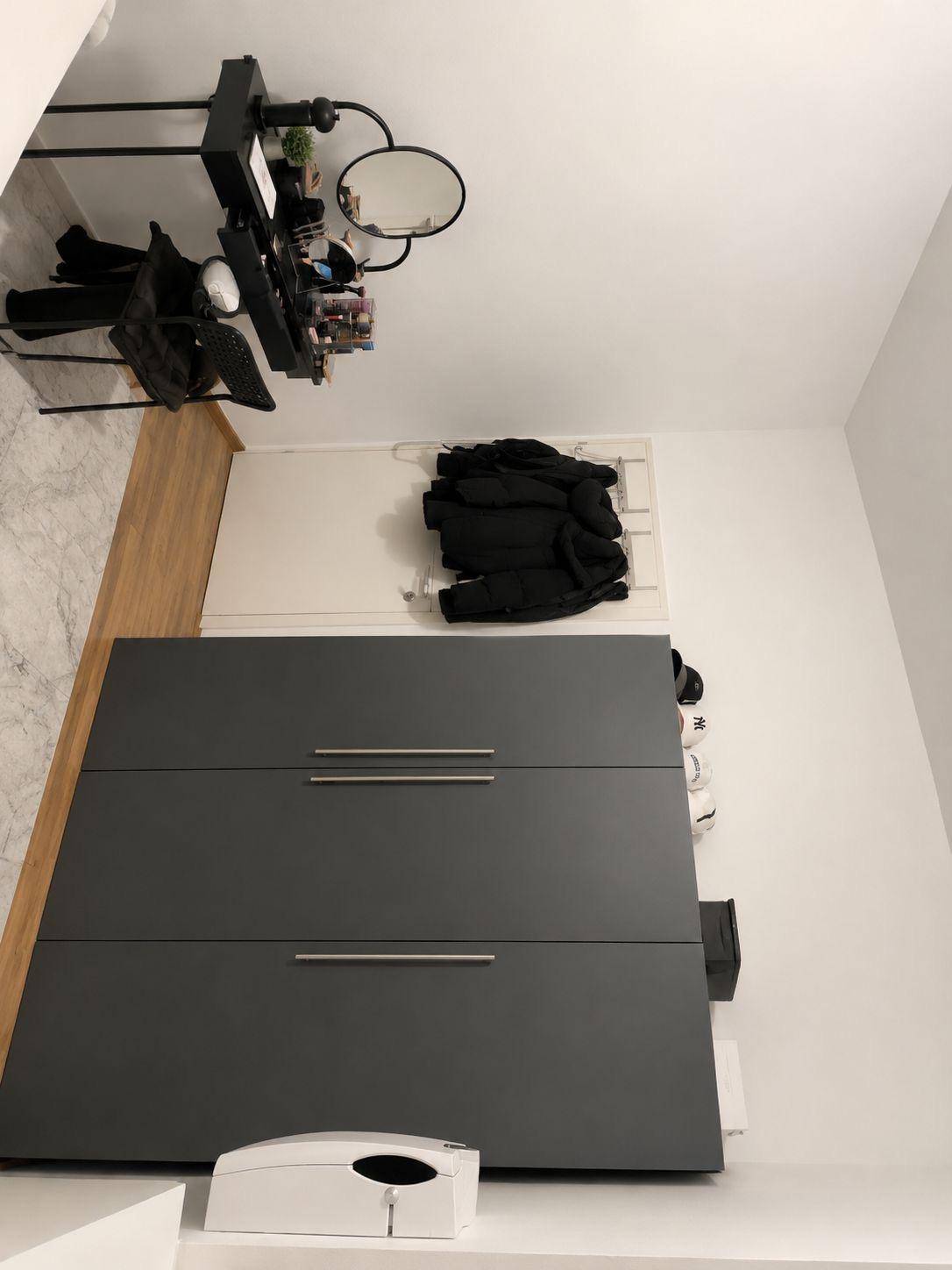 Schlafzimmer mit großem grauen Kleiderschrank und einem Schminktisch in modernem Stil.