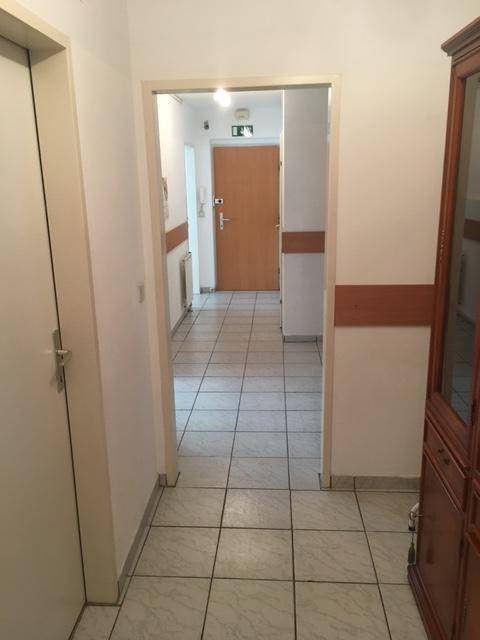 Gefliester Flur mit hellem Ambiente und Durchgang zu weiteren Bereichen.